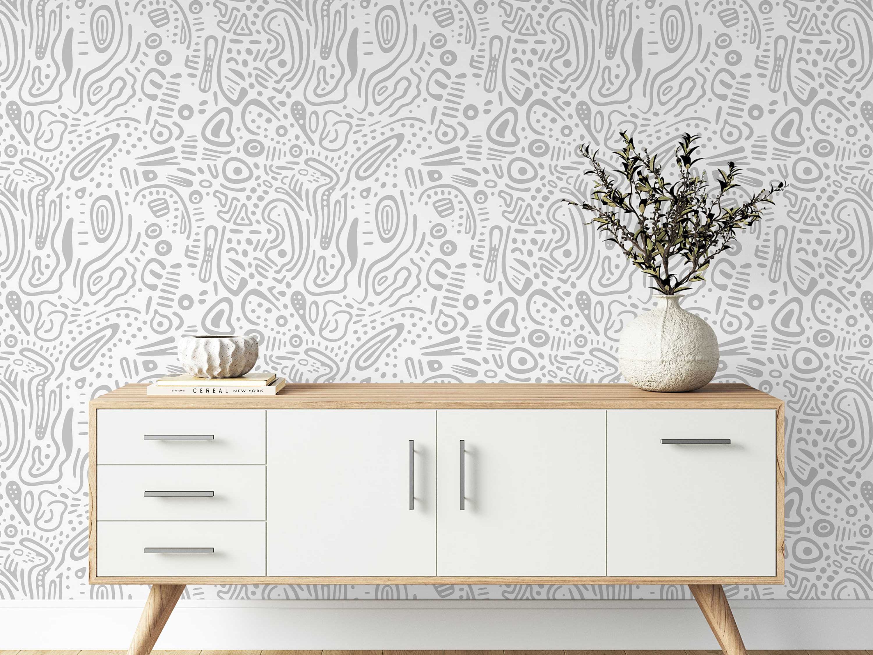 Wallpaper featuring a pattern of abstract, hand-drawn organic shapes, lines, and dots in light gray on a white background.
