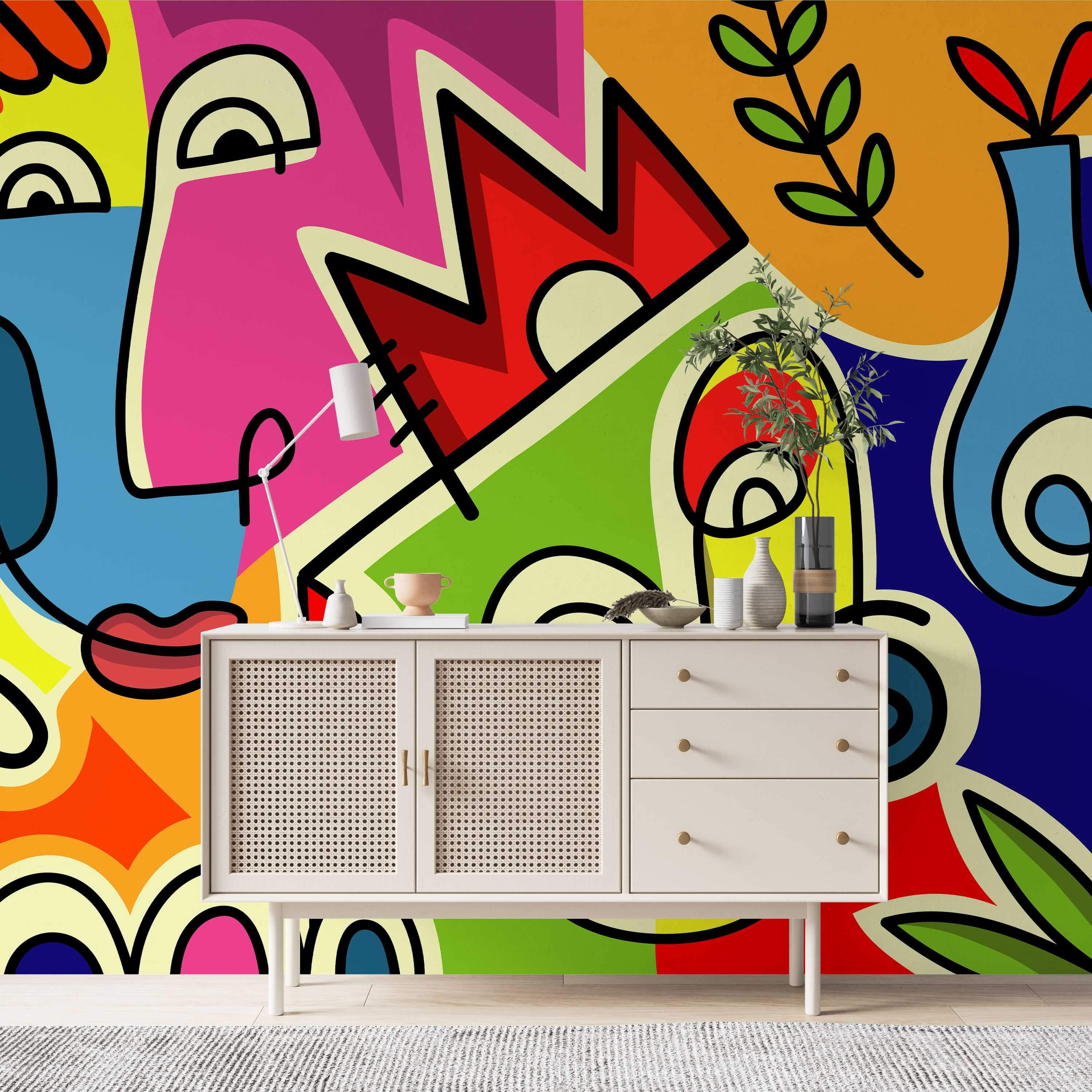 Colorful abstract mural featuring fragmented faces and bold geometric shapes outlined in black, using vibrant pink, blue, and yellow.