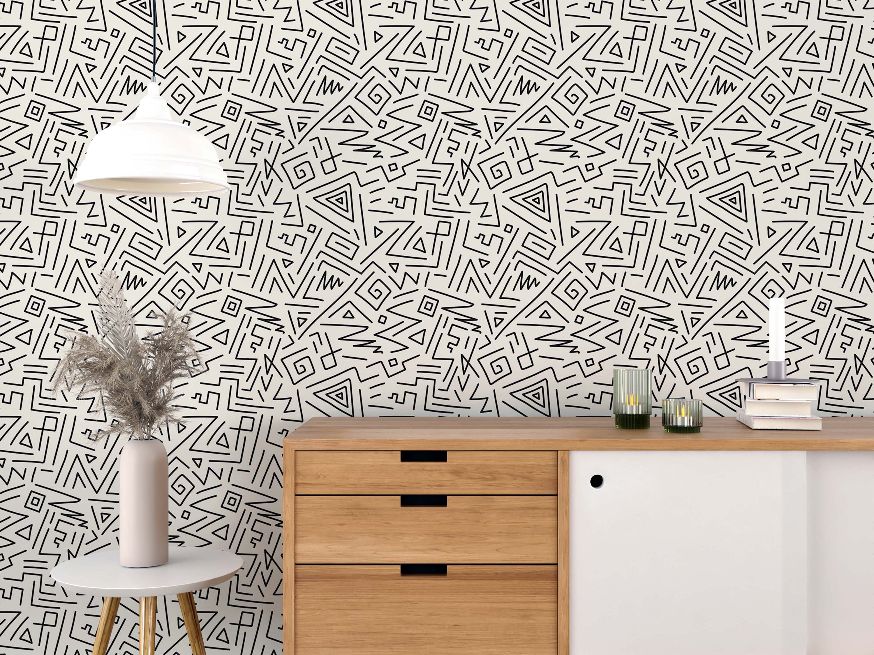 Wallpaper with an abstract geometric pattern of hand-drawn black lines, triangles, and spirals on a cream background.