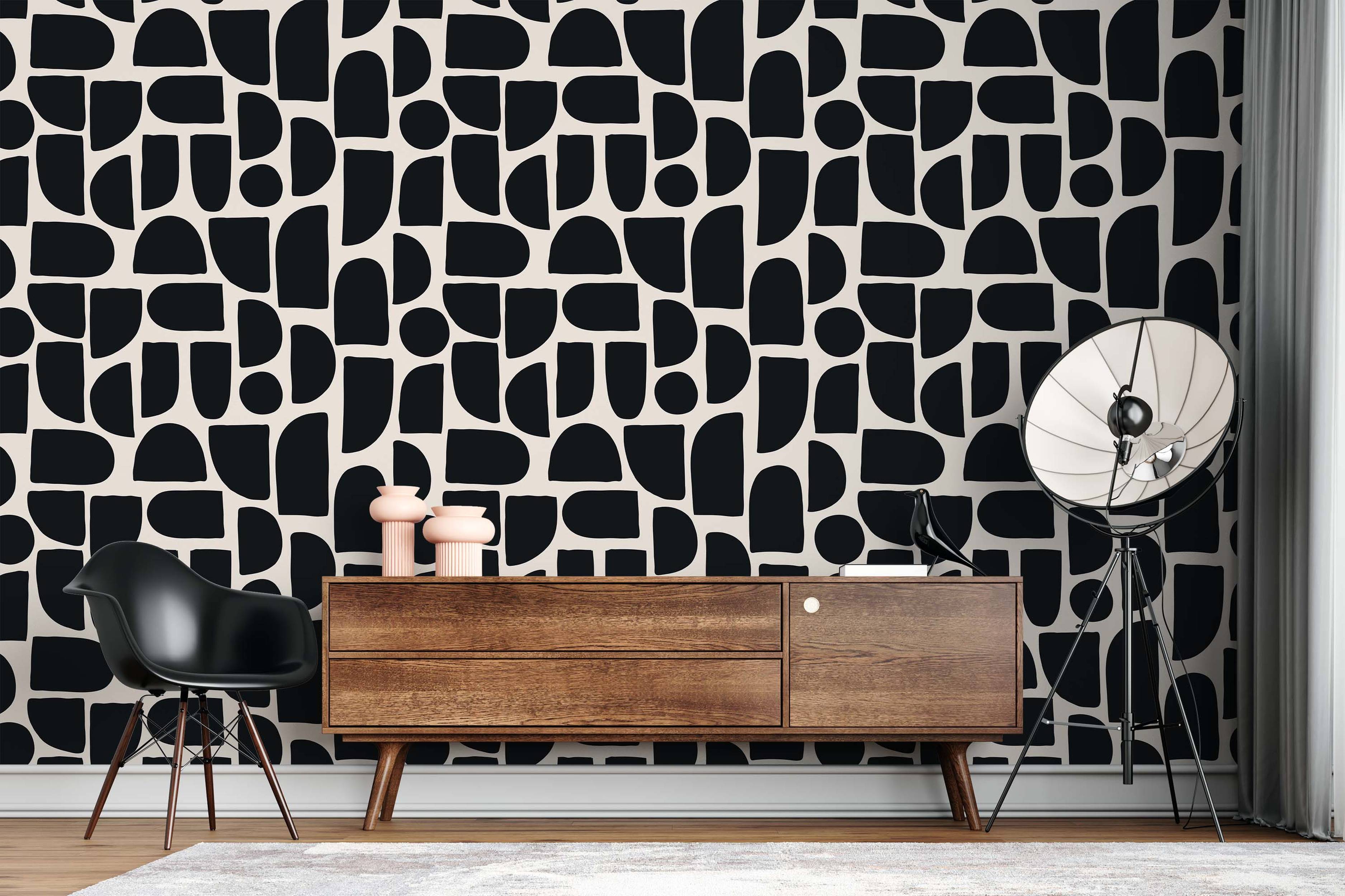 Abstract wallpaper with large, organic black shapes like rounded blocks and curves on a cream background.