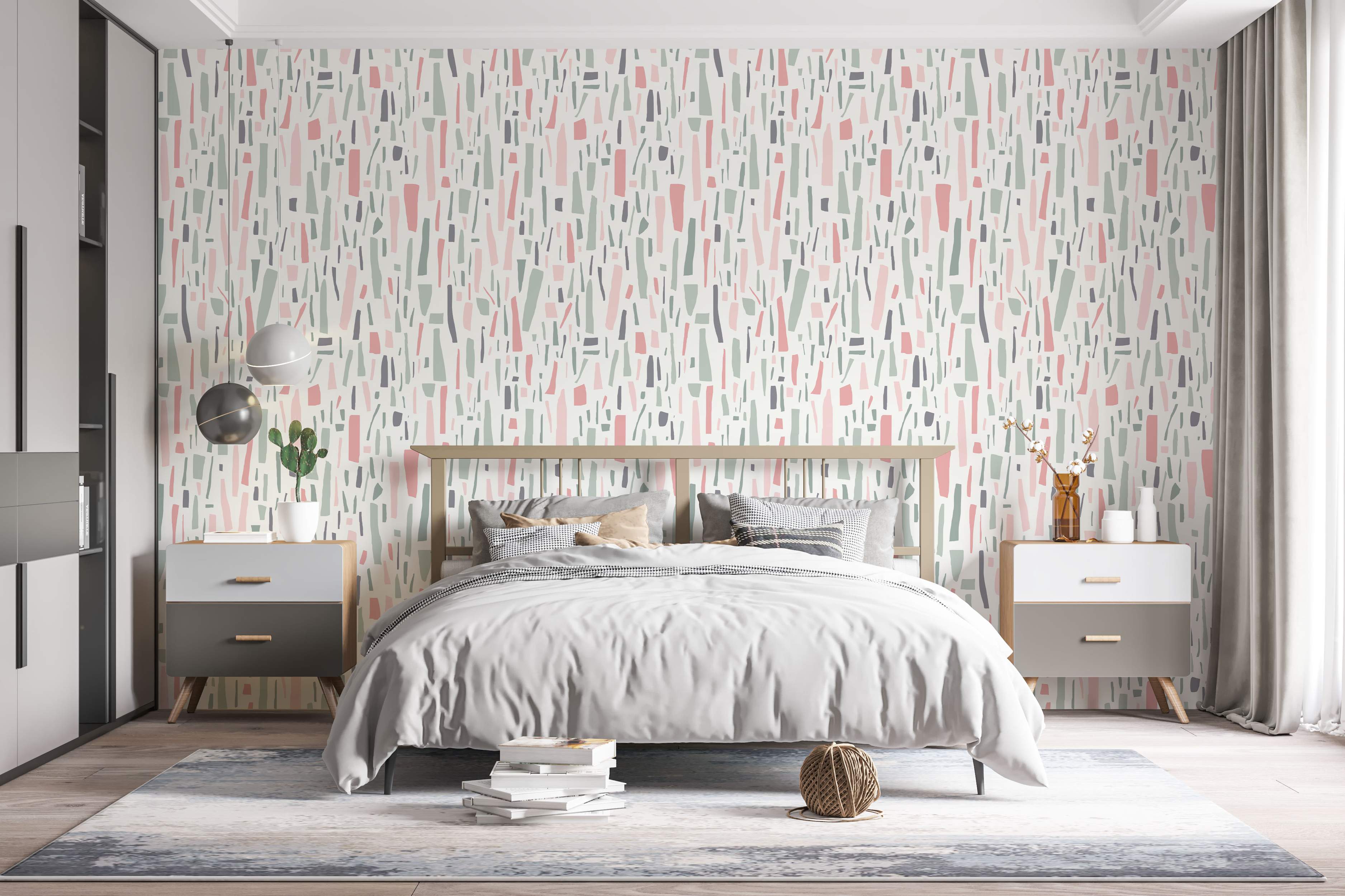 Abstract wallpaper featuring scattered, irregular vertical shapes in muted pink, sage green, and charcoal grey on an off-white field.