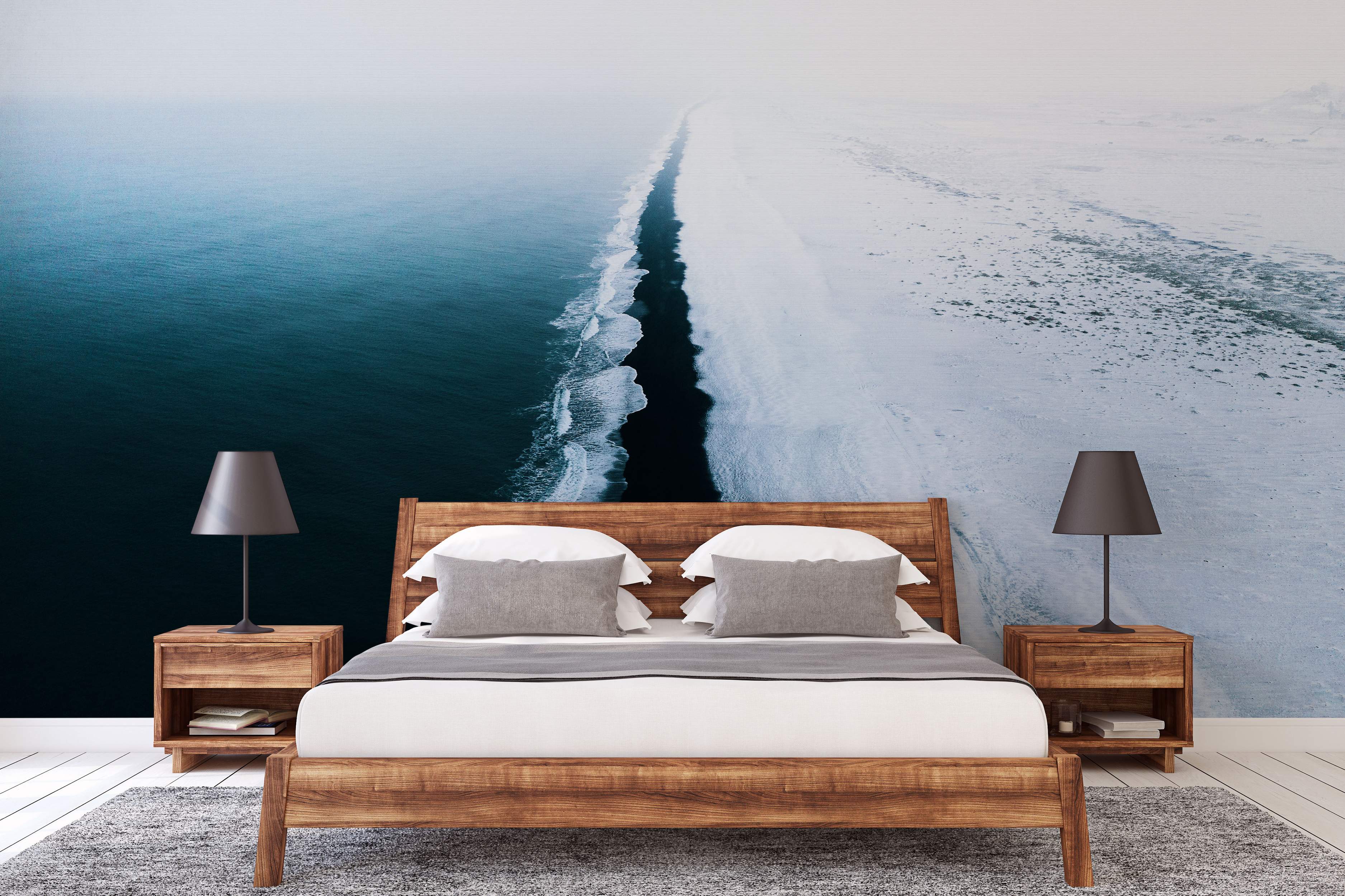 Mural featuring an aerial view of a deep blue ocean contrasting sharply with a white, snow-covered shoreline under fog.