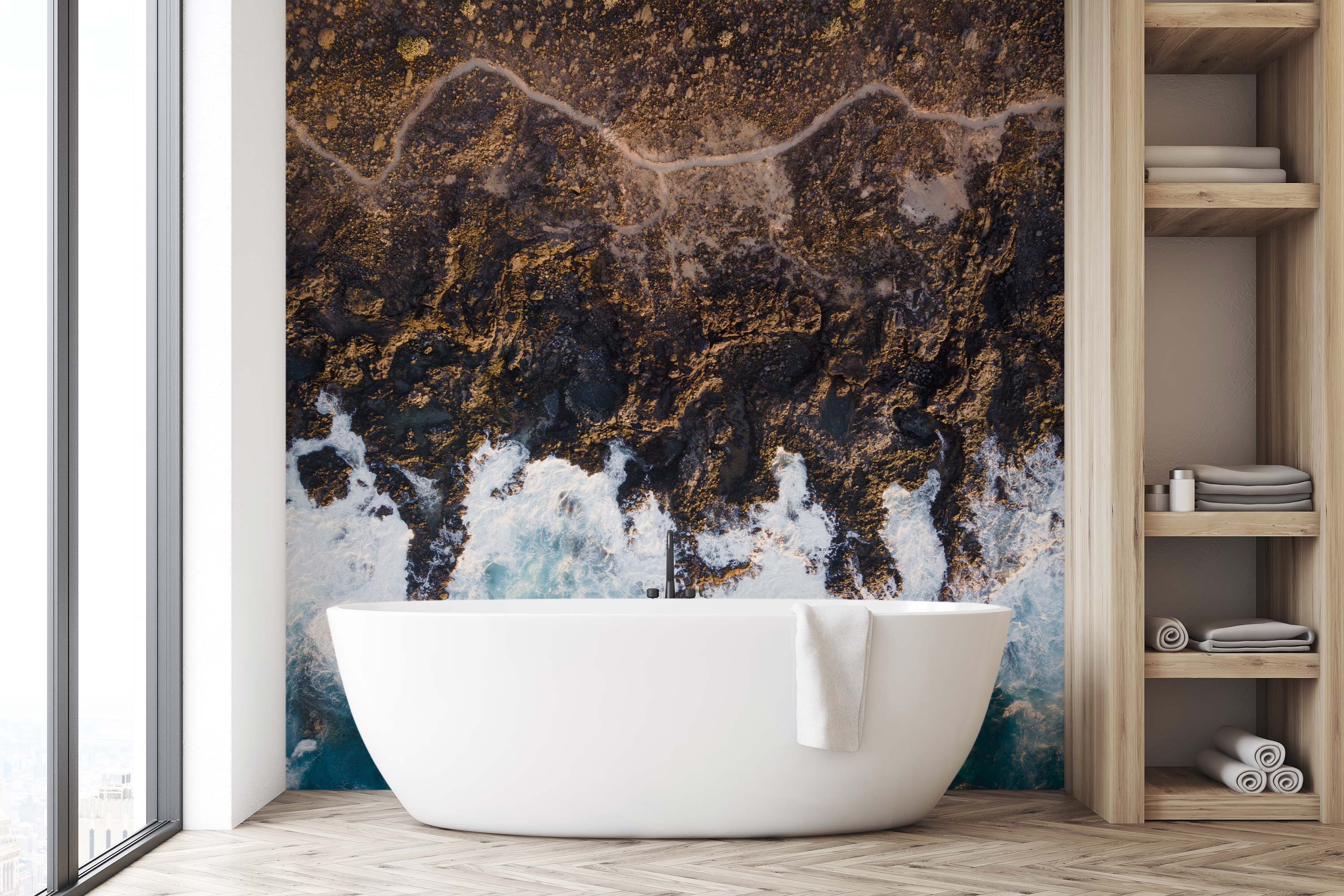 A photographic wall mural depicting an aerial, top-down view of a rugged coastline with dark rocks and crashing blue and white waves.