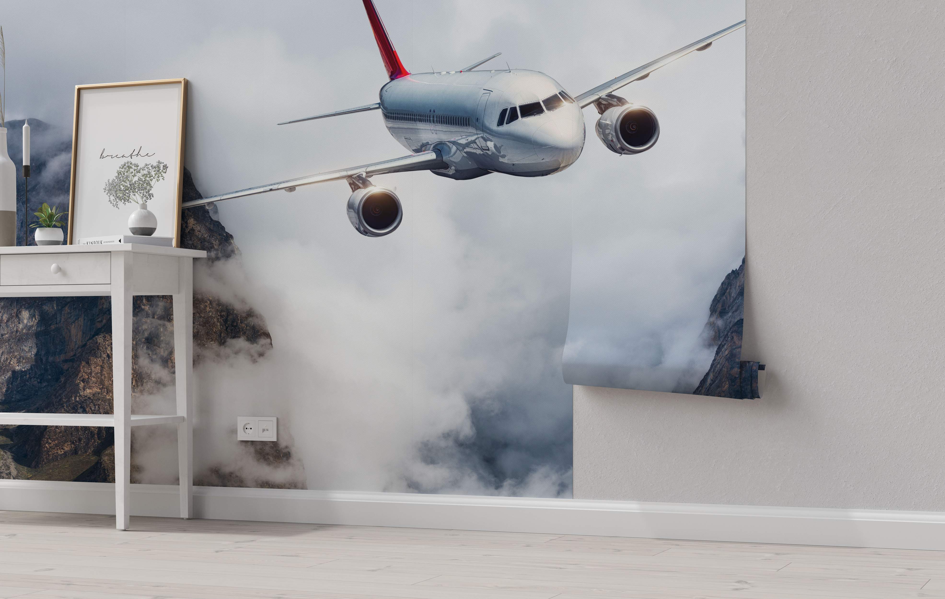 Mural depicting a silver airplane with a red tail flying through white clouds and rocky mountains.