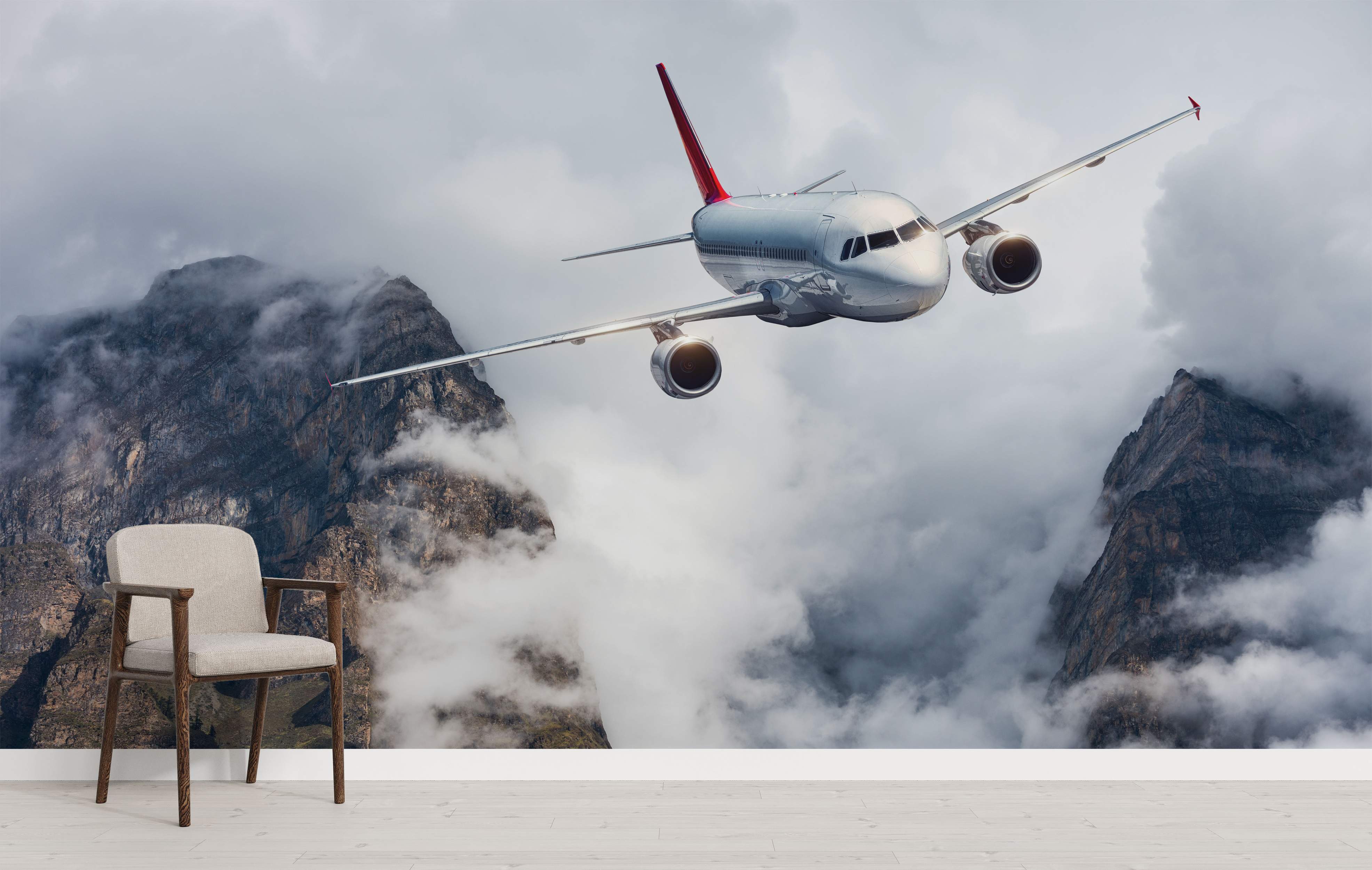 Photorealistic mural featuring a silver airplane with a red tail flying amidst grey, cloud-covered mountain peaks.
