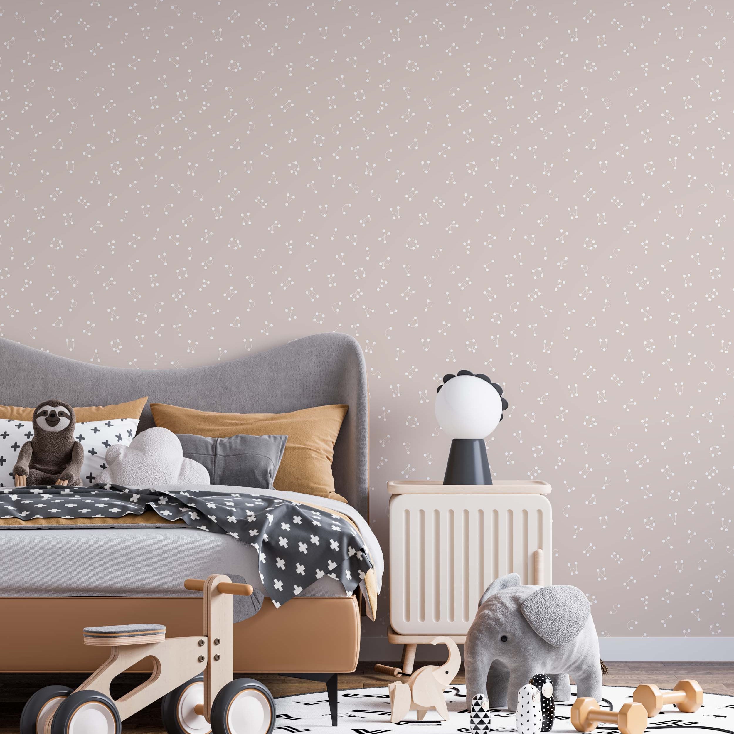 A playful wallpaper with alphabet letters designed as constellations in off-white on a dusty pink background.