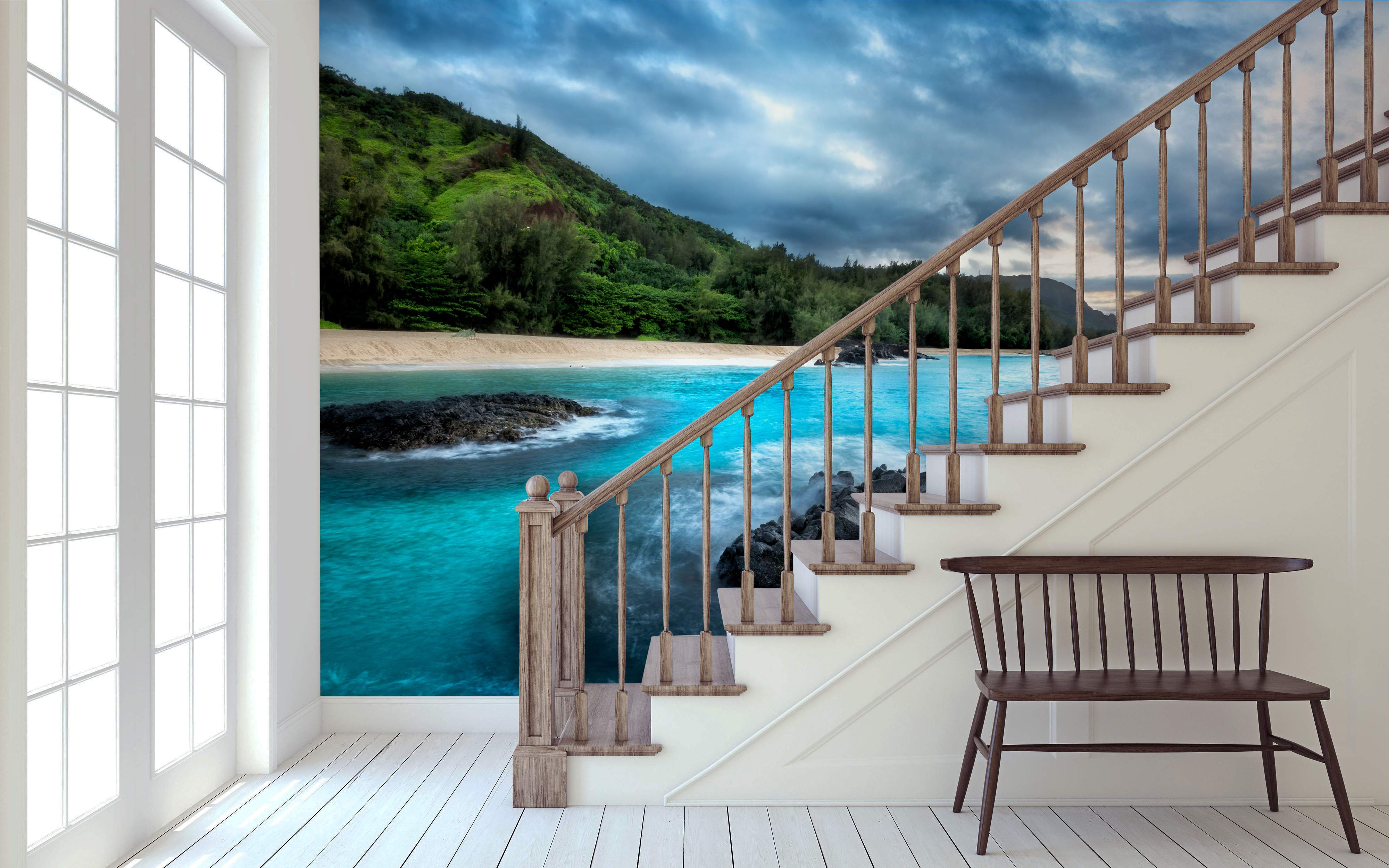 Mural depicting a tropical beach cove with vibrant turquoise water, dark rocks, sandy shore, green hills, and a dramatic cloudy sky.