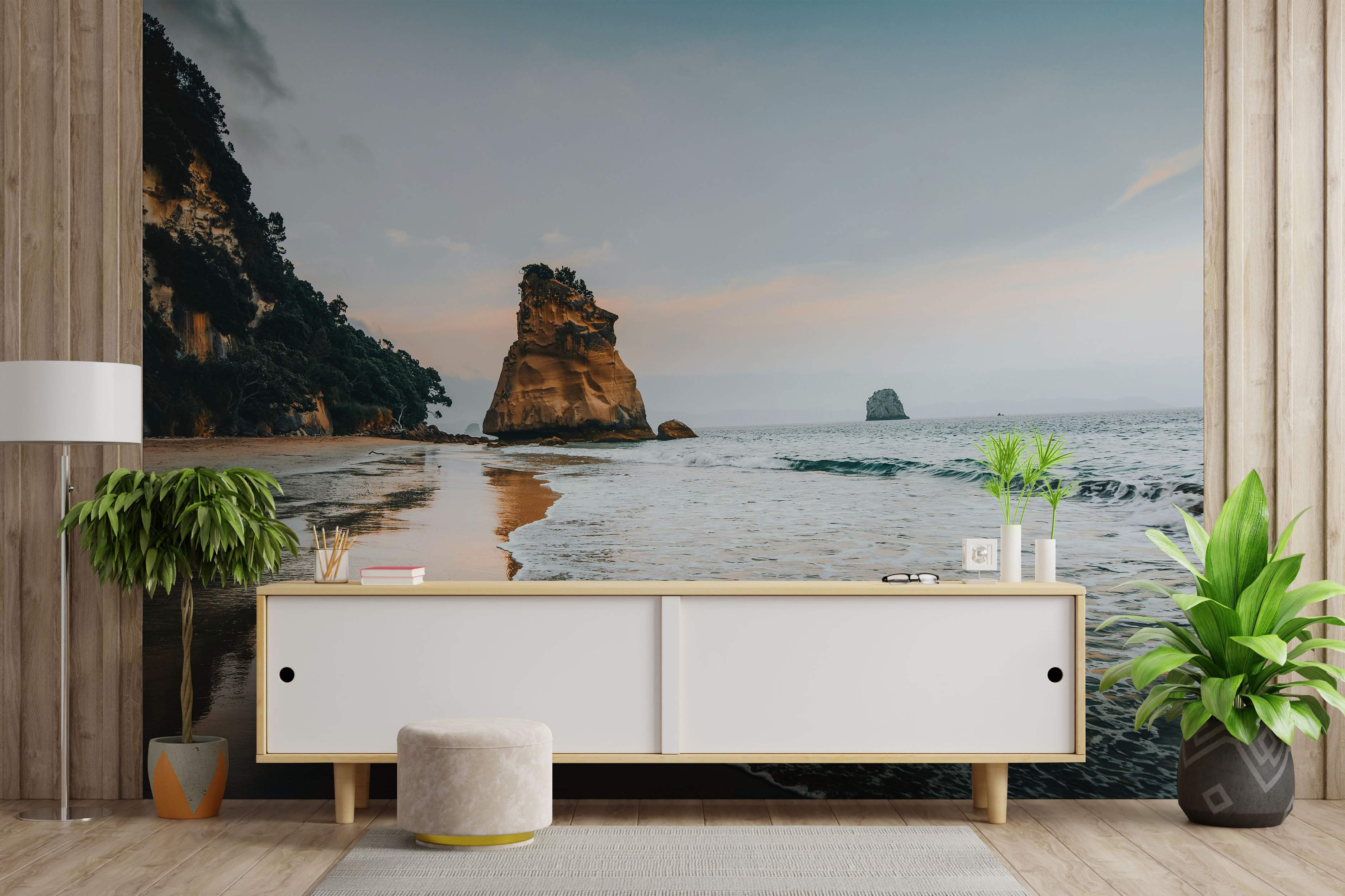 Photographic mural of a serene beach at dusk, featuring a large sea stack, gentle waves, and coastal cliffs under a soft sky.