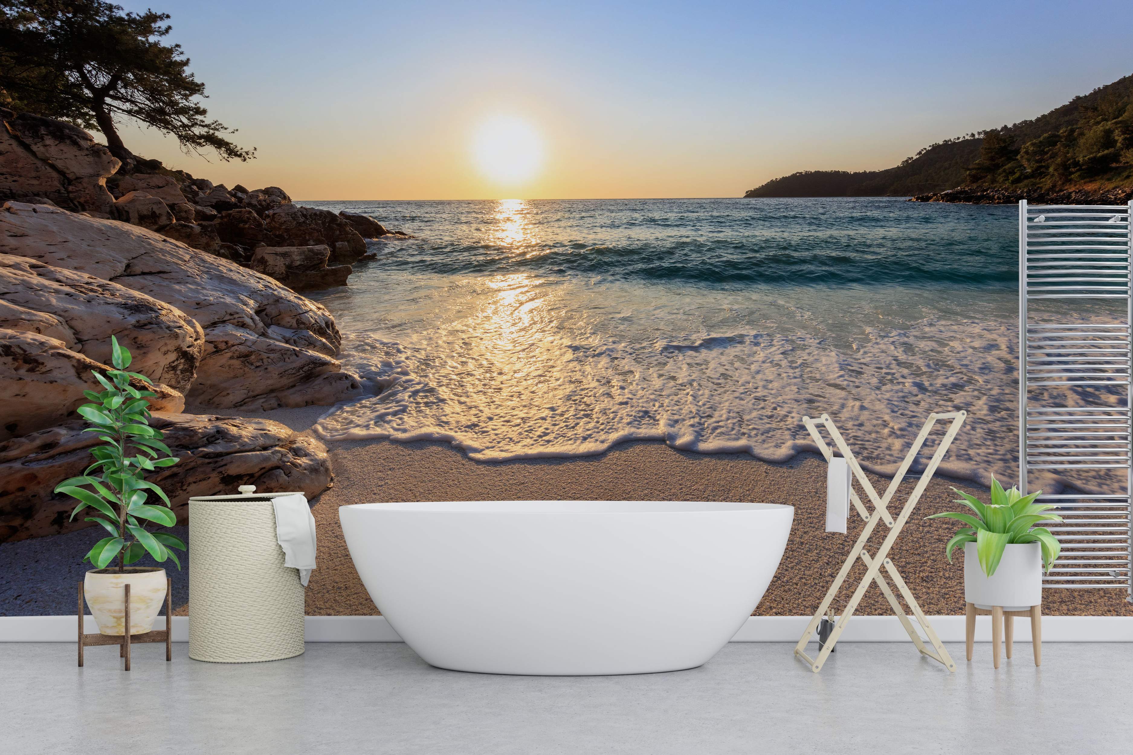 Wall mural capturing a tranquil beach scene at sunset, featuring rocky coastlines, calm ocean waves, and warm golden light.