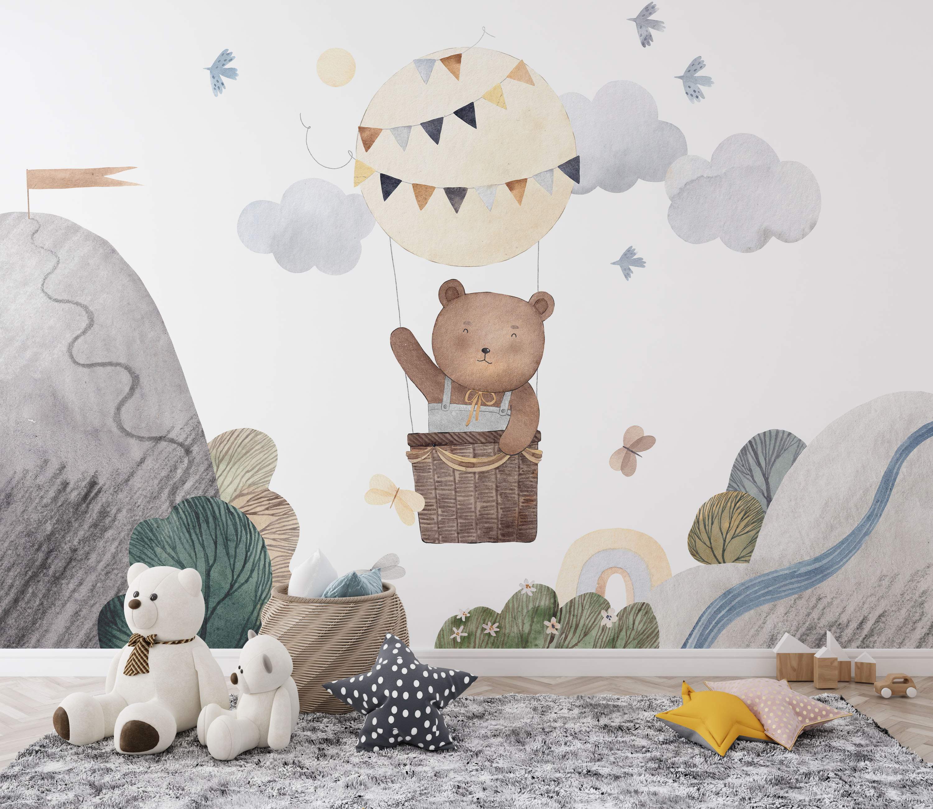 Watercolor mural featuring a cute bear in a hot air balloon amidst clouds, birds, mountains, and a rainbow. Soft, painterly style.