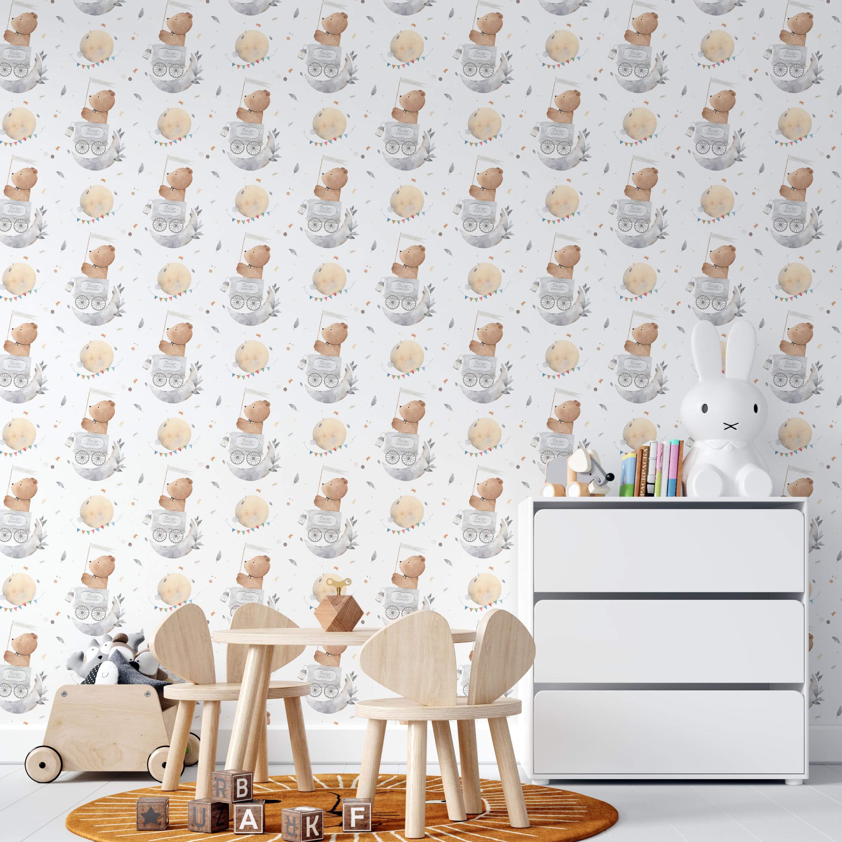 Watercolor wallpaper featuring a repeating pattern of brown teddy bears in gray moon carriages, yellow moons with bunting, and gray leaves on a white background.
