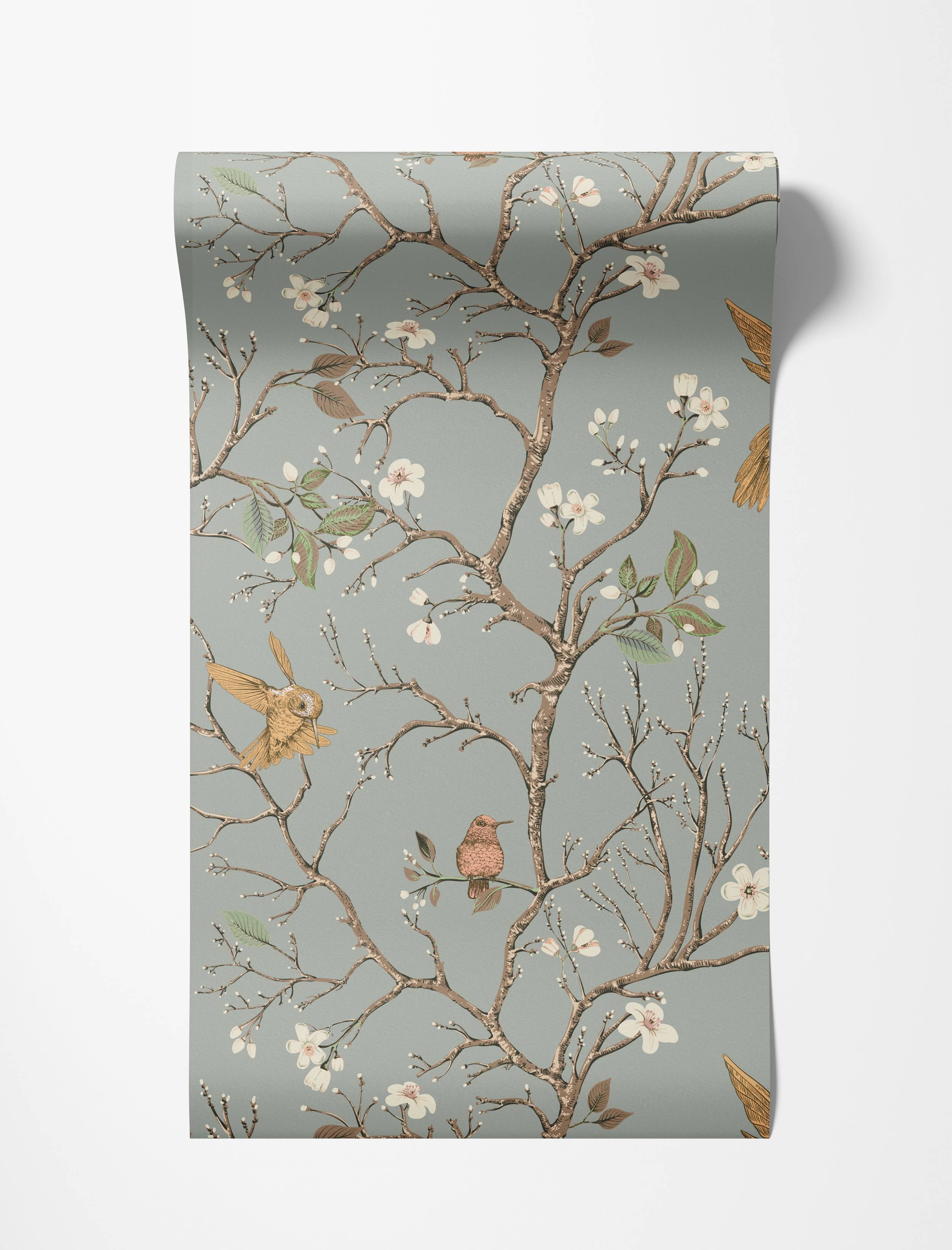 A Chinoiserie-style wallpaper with birds and blossoming branches in brown, pink, and yellow on a gray-blue background.