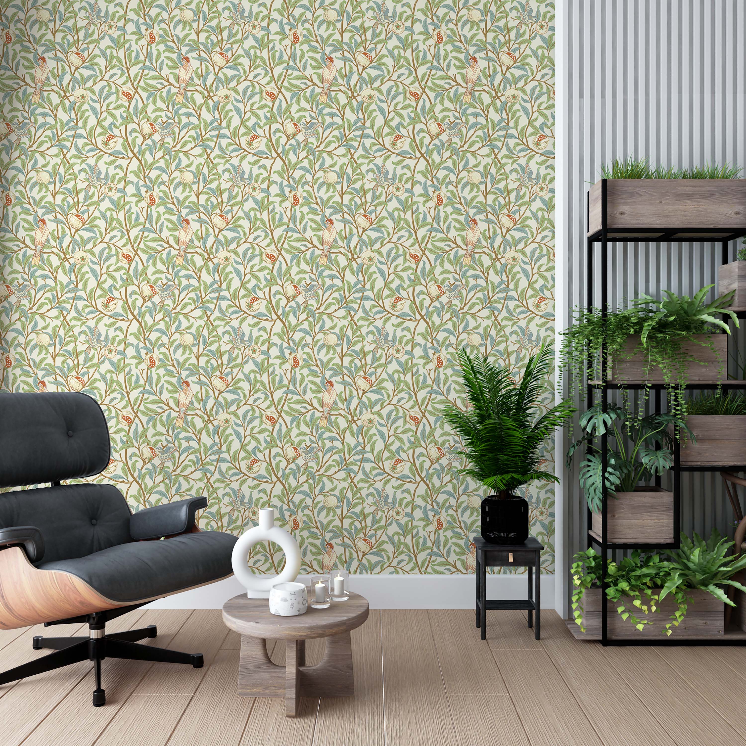 Arts and Crafts style wallpaper with birds on branches with green and blue leaves and pomegranates on a cream background.
