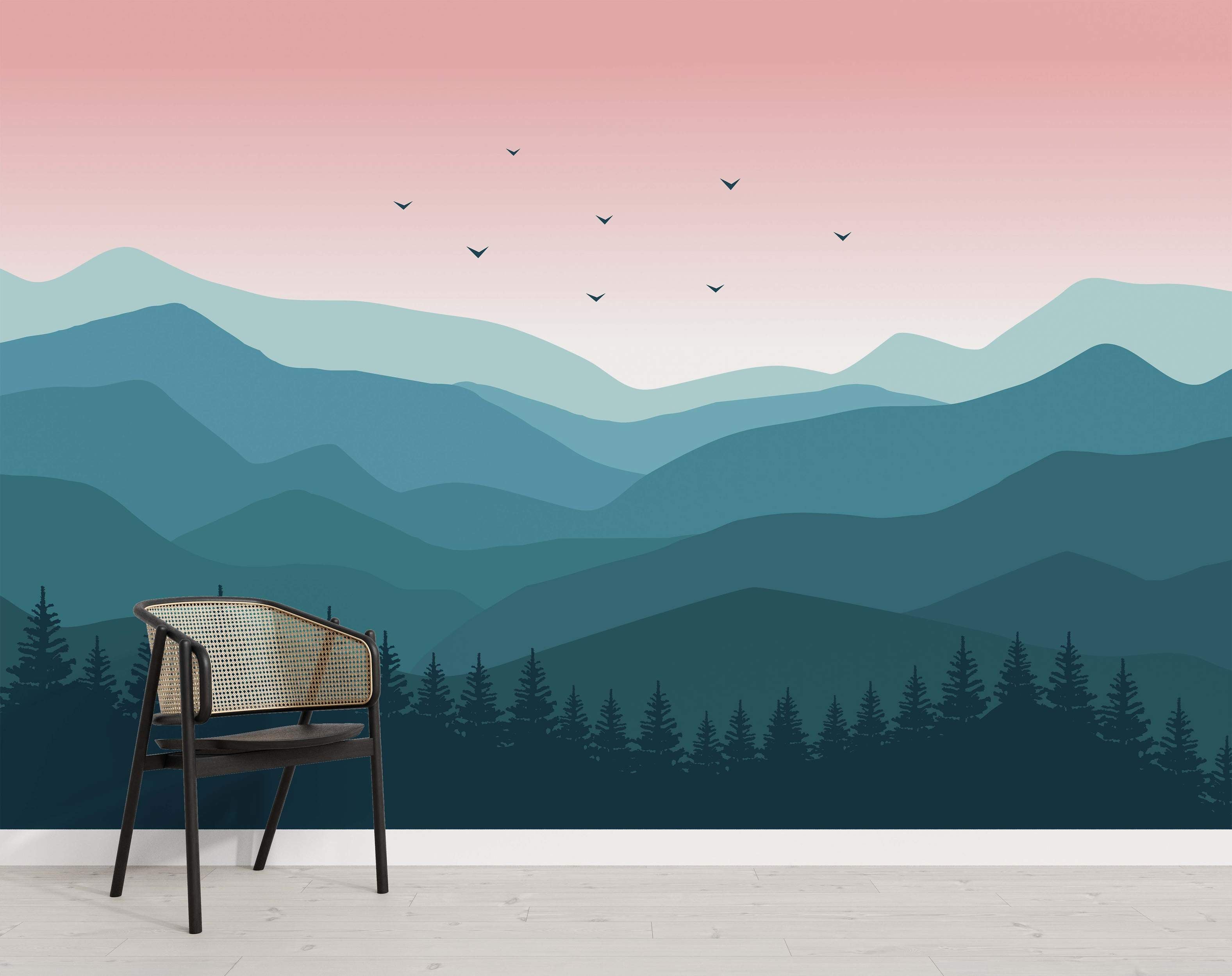 Stylized mountain landscape mural with layered blue-teal peaks, a soft pink gradient sky with bird silhouettes, and dark foreground trees.