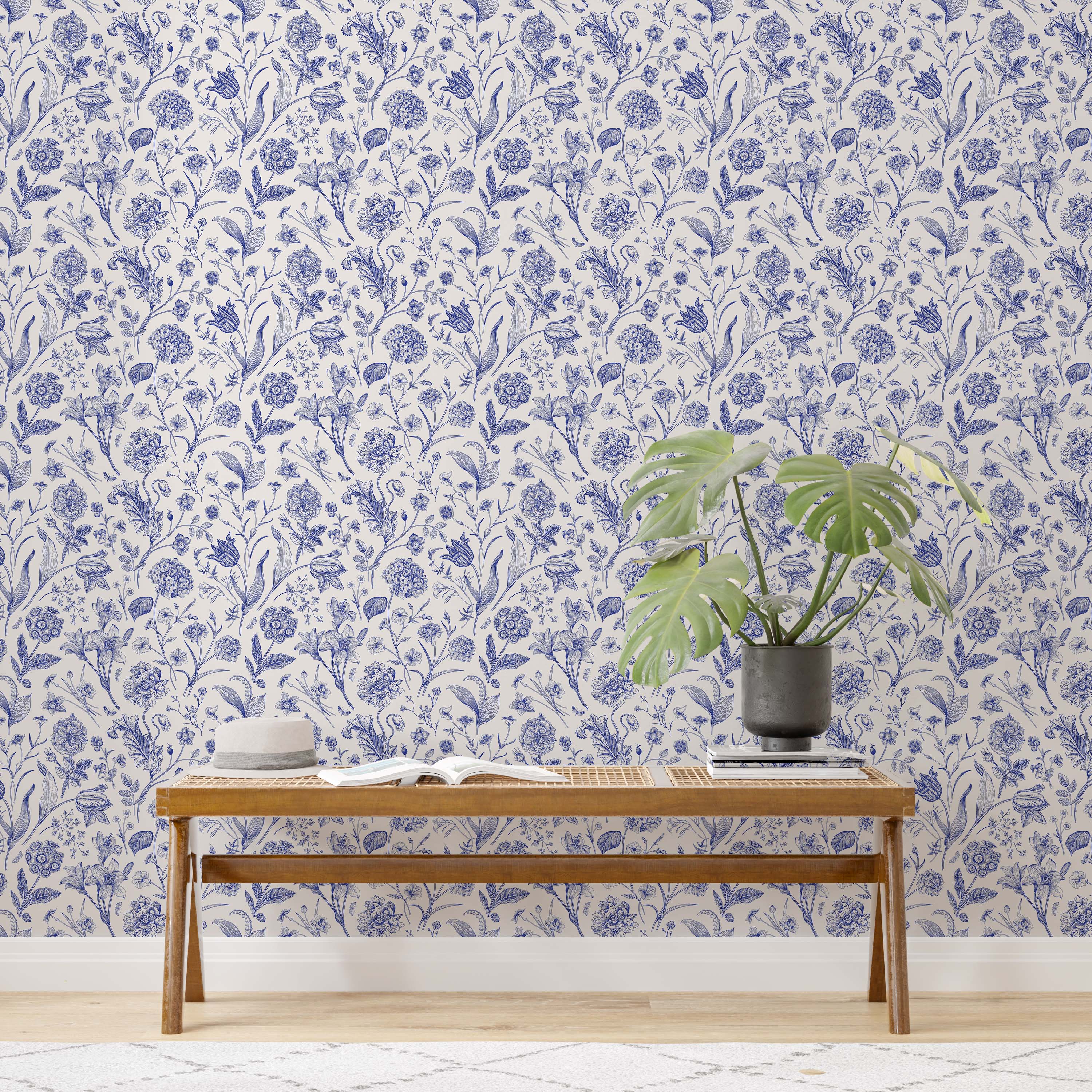 Vintage botanical wallpaper featuring detailed floral illustrations in blue ink on a warm, off-white background.