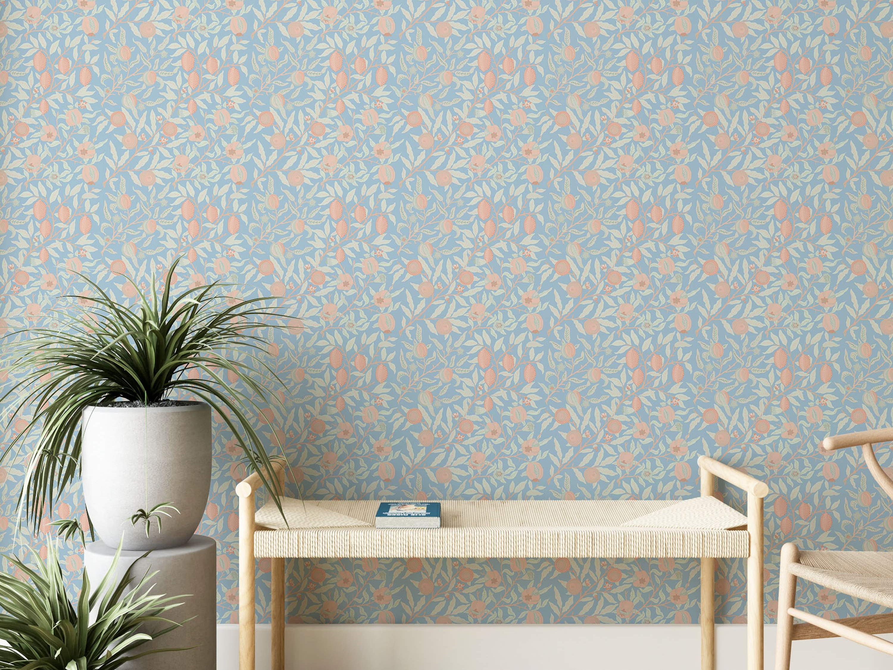 Light blue wallpaper featuring a repeating botanical pattern of cream leaves and peach fruits and flowers on intertwined branches.