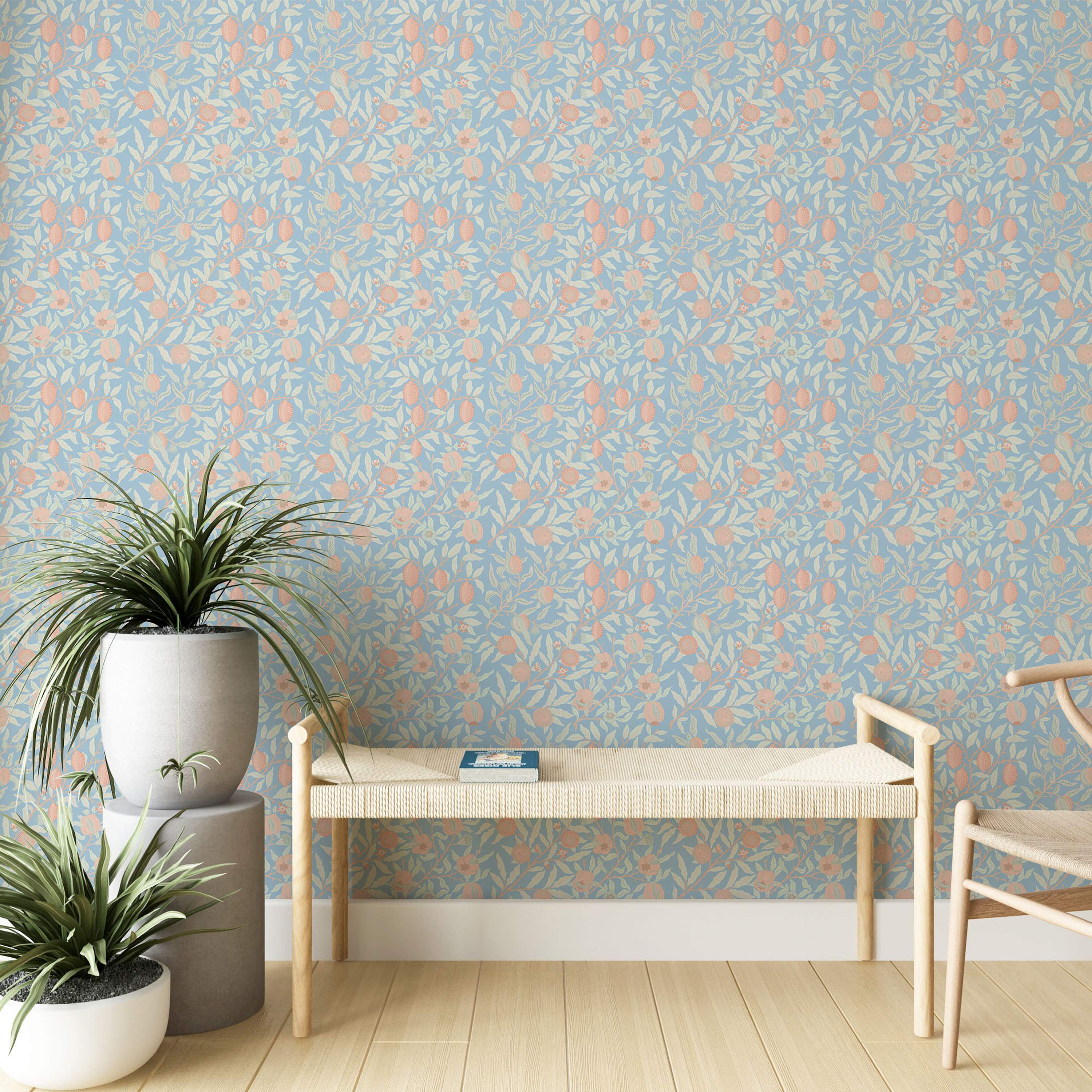 Light blue wallpaper featuring a repeating botanical pattern of cream leaves and peach fruits and flowers on intertwined branches.
