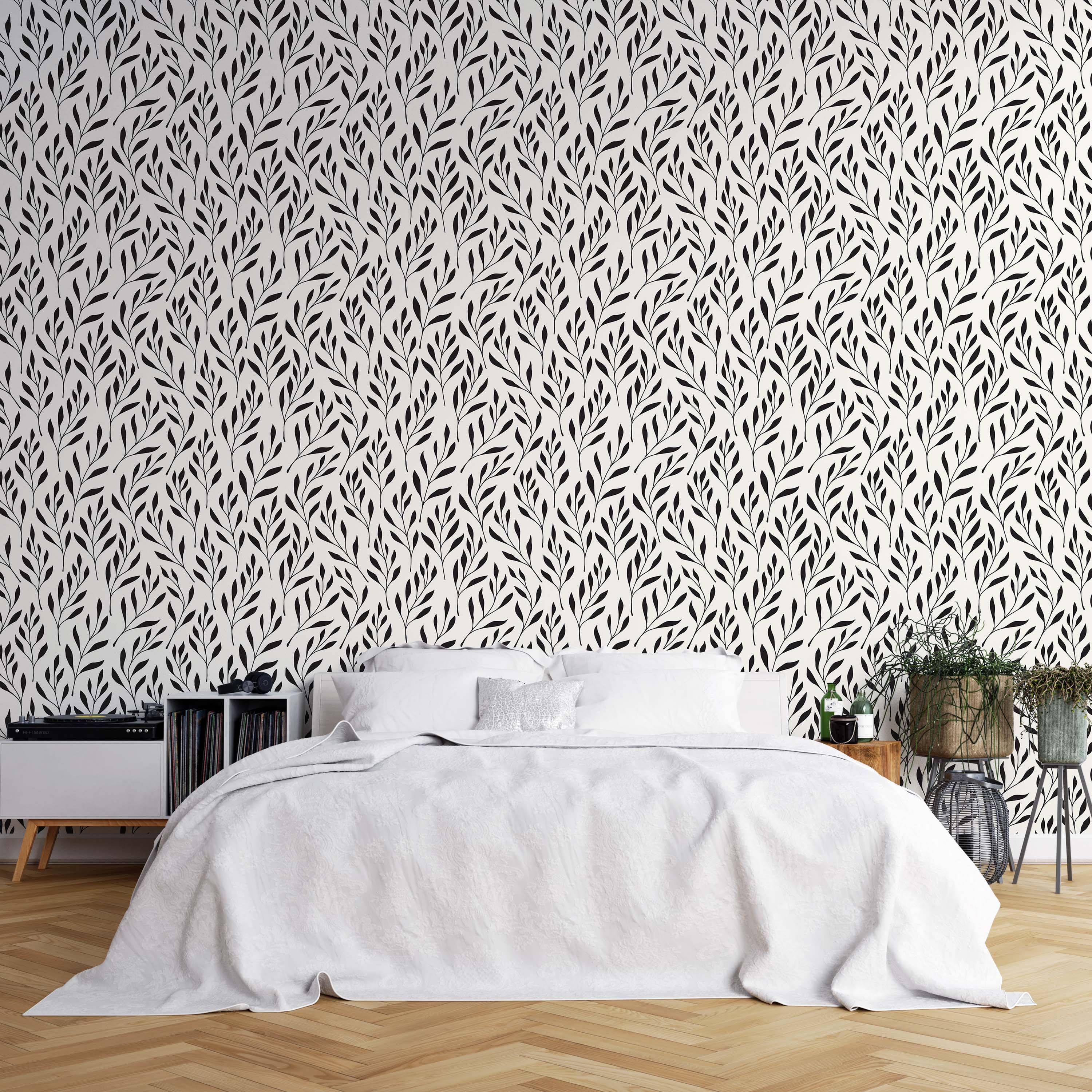 Wallpaper featuring a repeating pattern of simple black botanical branches and leaves on an off-white background.