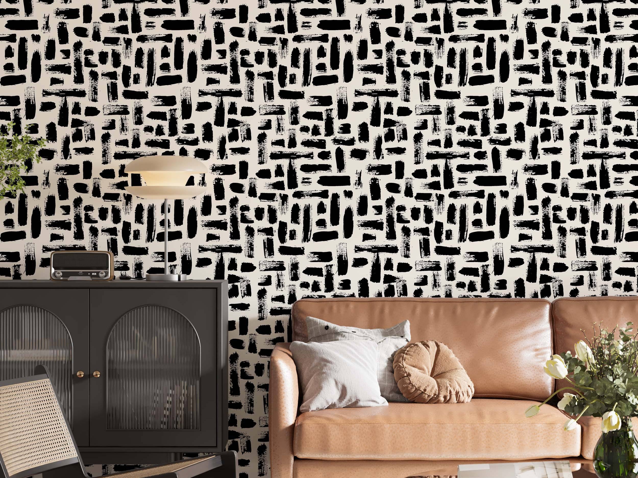Abstract wallpaper featuring varied black brushstrokes scattered across a light beige background.
