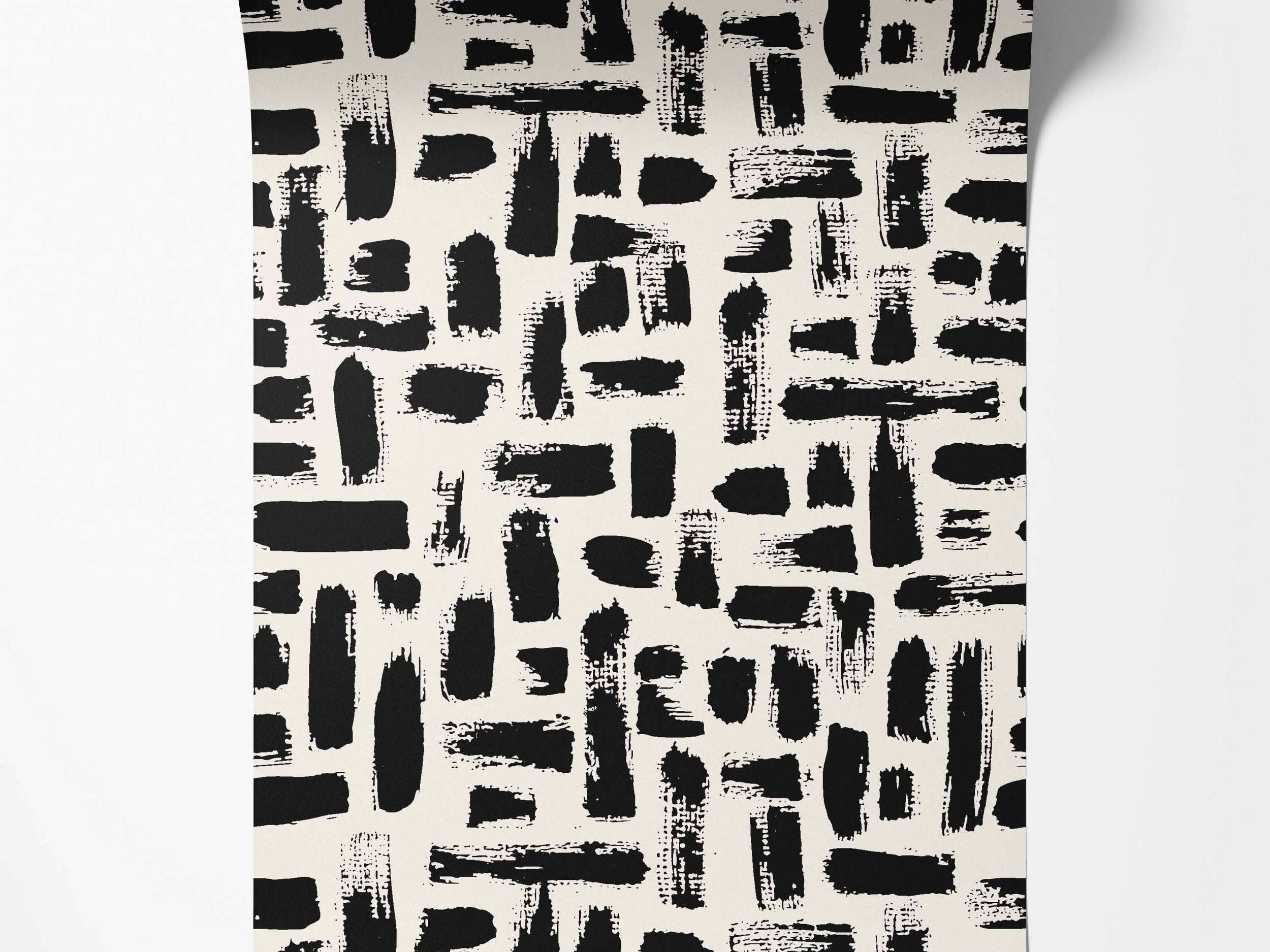 Abstract wallpaper with textured black brushstrokes randomly scattered across an off-white background.