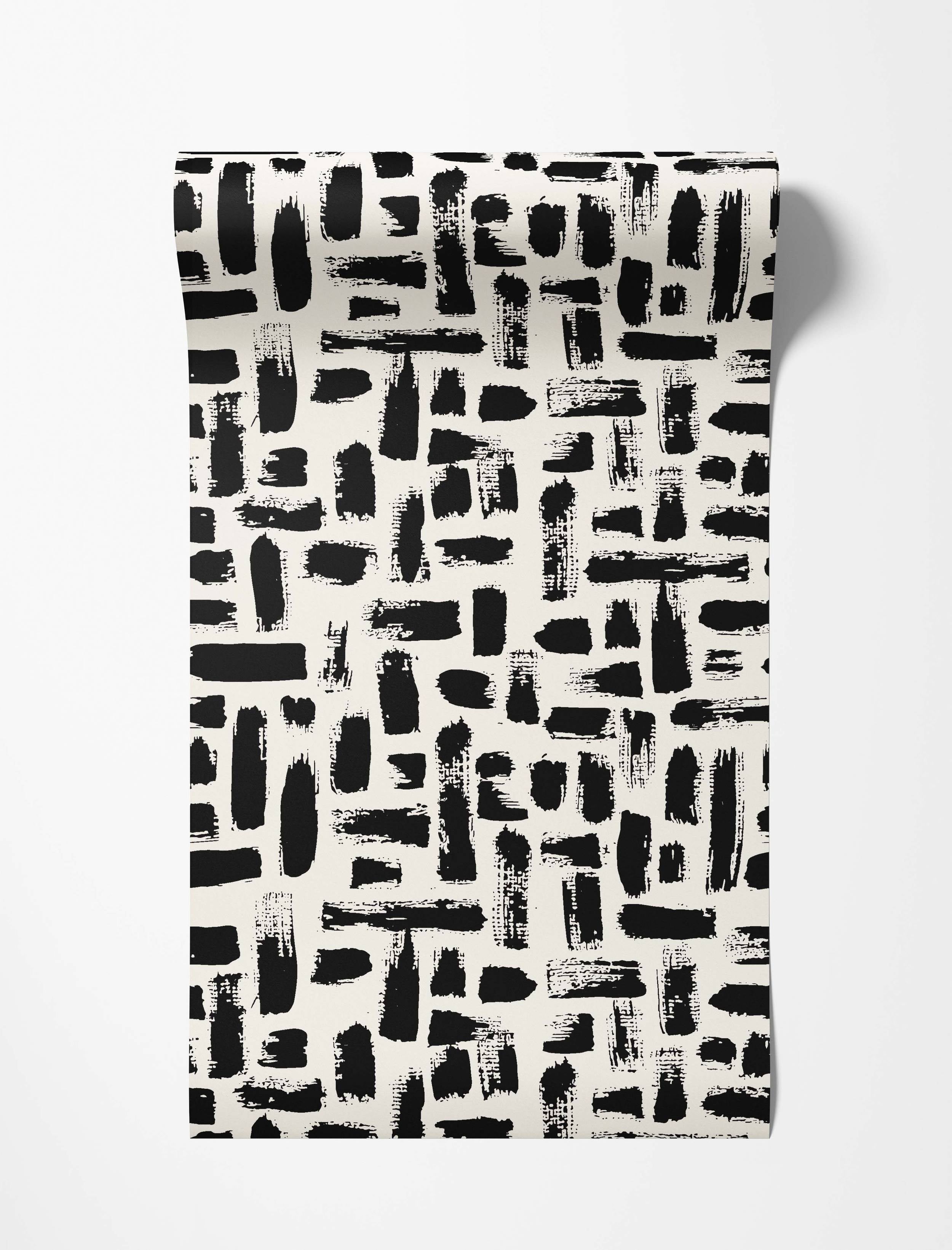 Abstract wallpaper with textured black brushstrokes randomly scattered across an off-white background.