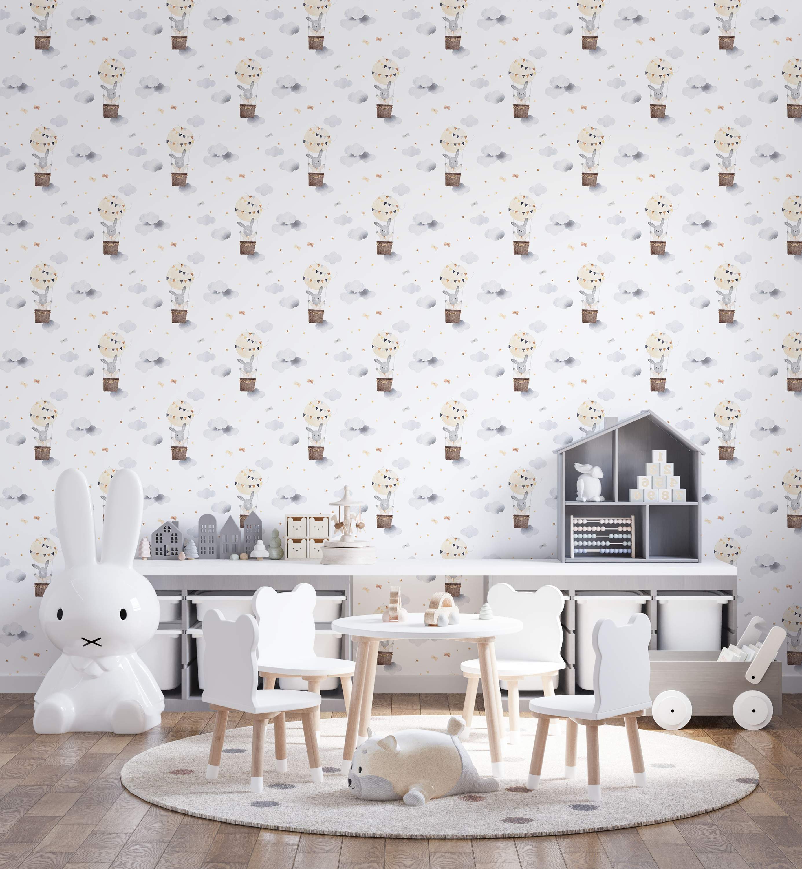Watercolor wallpaper featuring gray bunnies in brown hot air balloons among gray clouds, gold stars, and beige bows on white.
