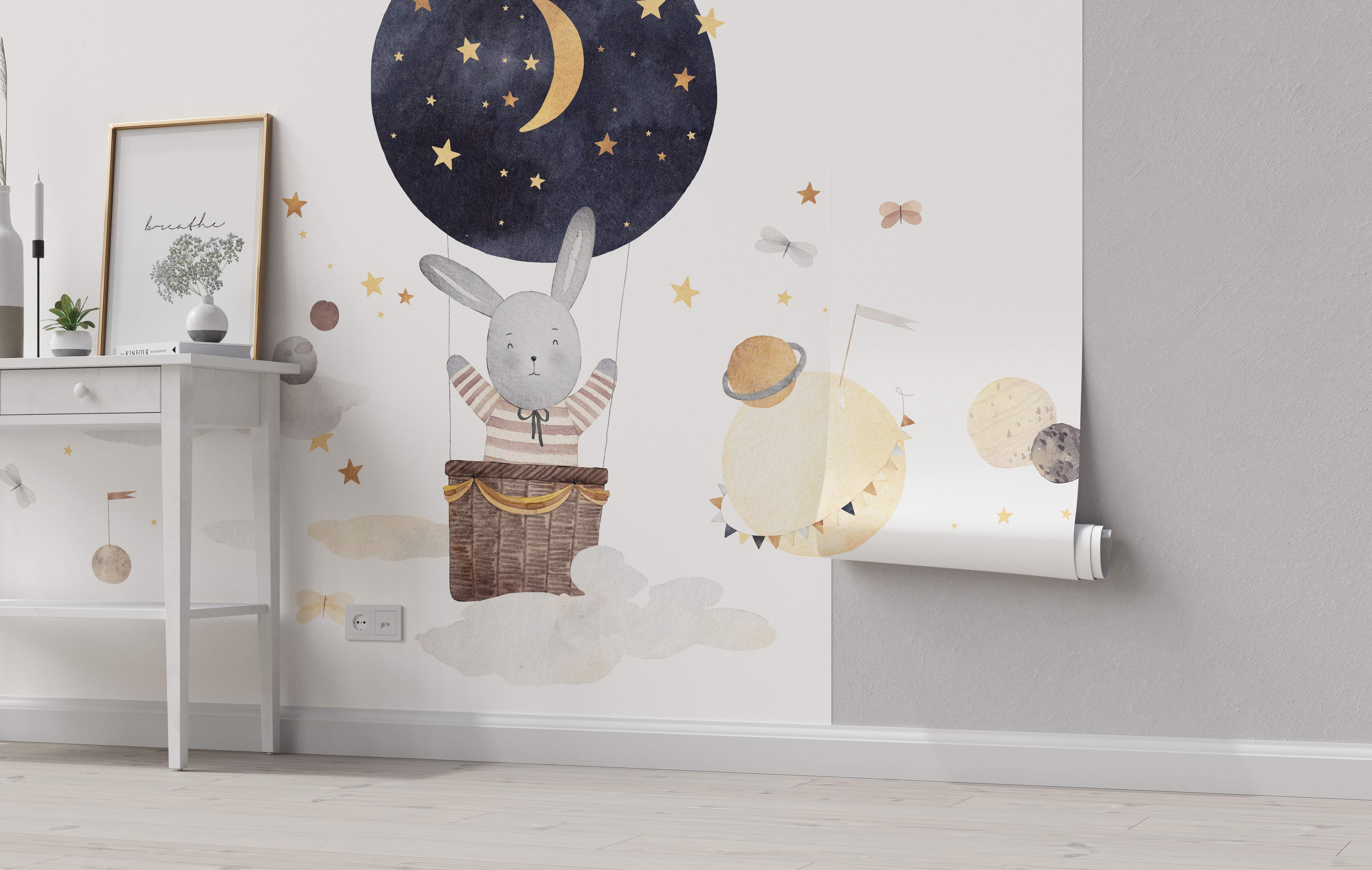 Whimsical mural featuring a gray bunny in a night-sky hot air balloon with gold stars, surrounded by watercolor planets and clouds.