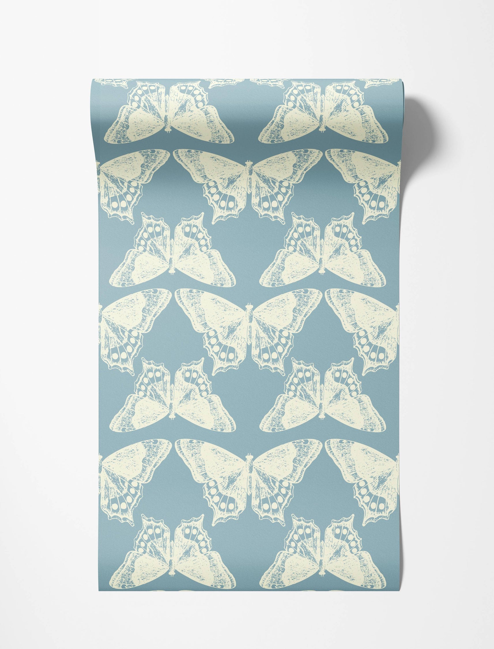 A repeating wallpaper pattern of distressed cream butterflies arranged symmetrically on a slate blue background.