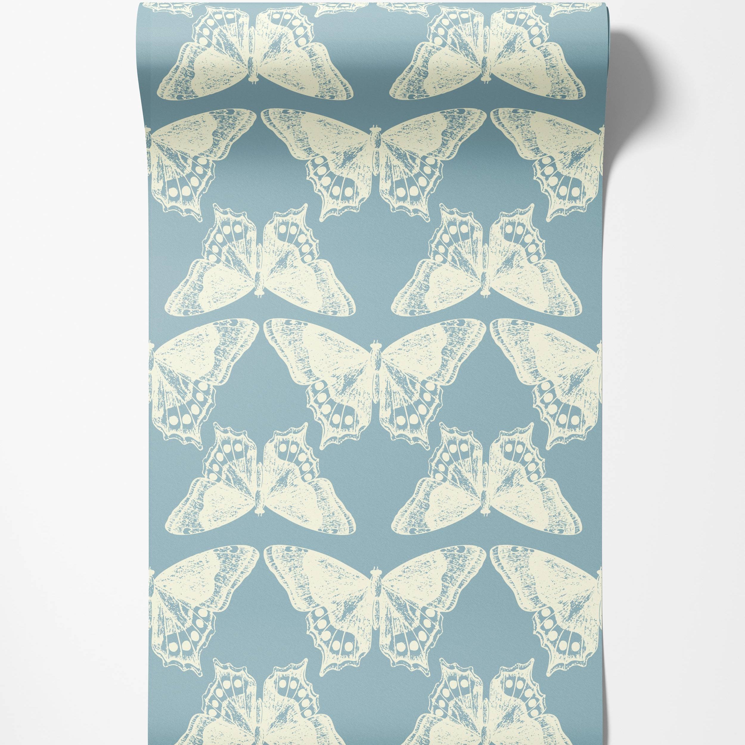 A repeating wallpaper pattern of distressed cream butterflies arranged symmetrically on a slate blue background.