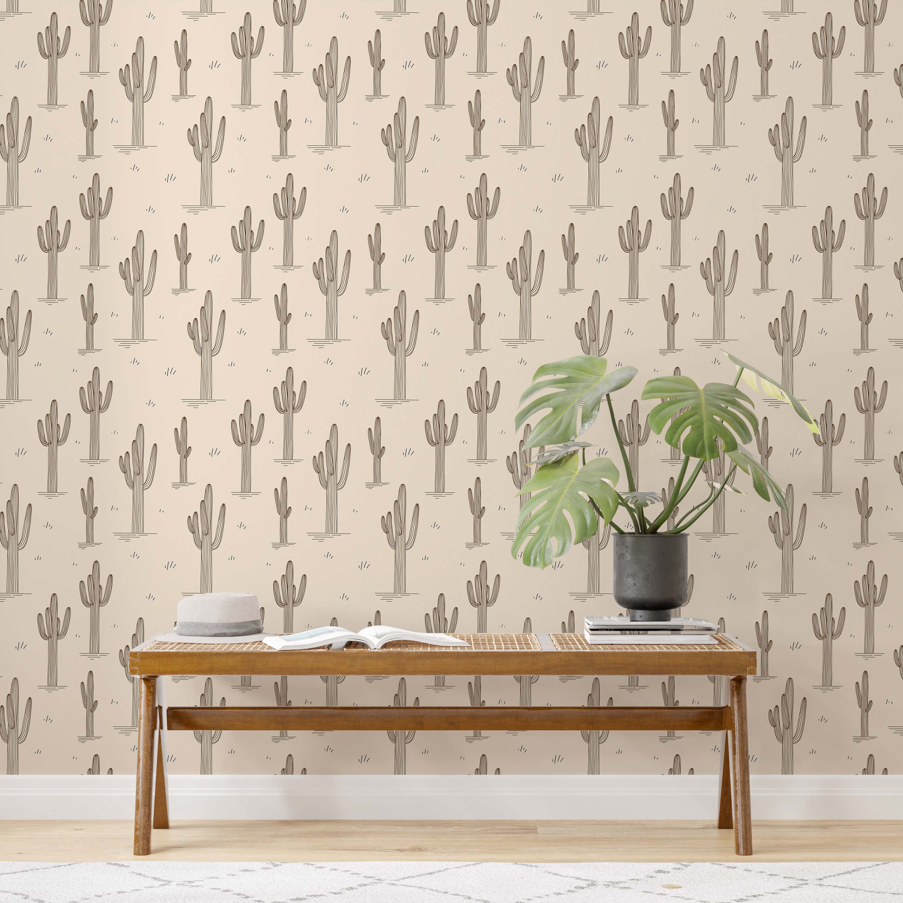 Beige wallpaper with a repeating pattern of brown line-art saguaro cacti and small tufts of grass.