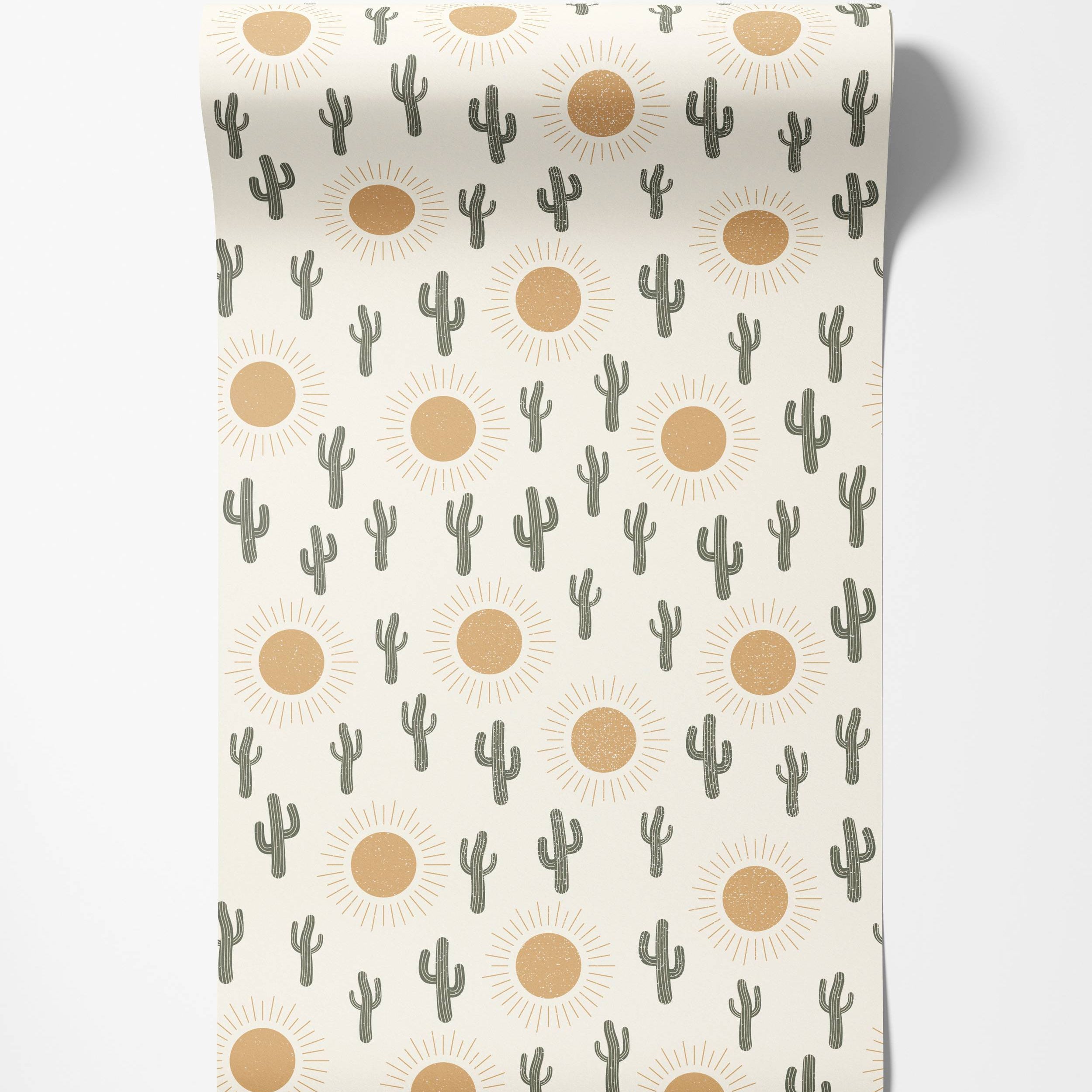 Wallpaper with a repeating pattern of stylized dark green cacti and distressed orange suns on an off-white background.