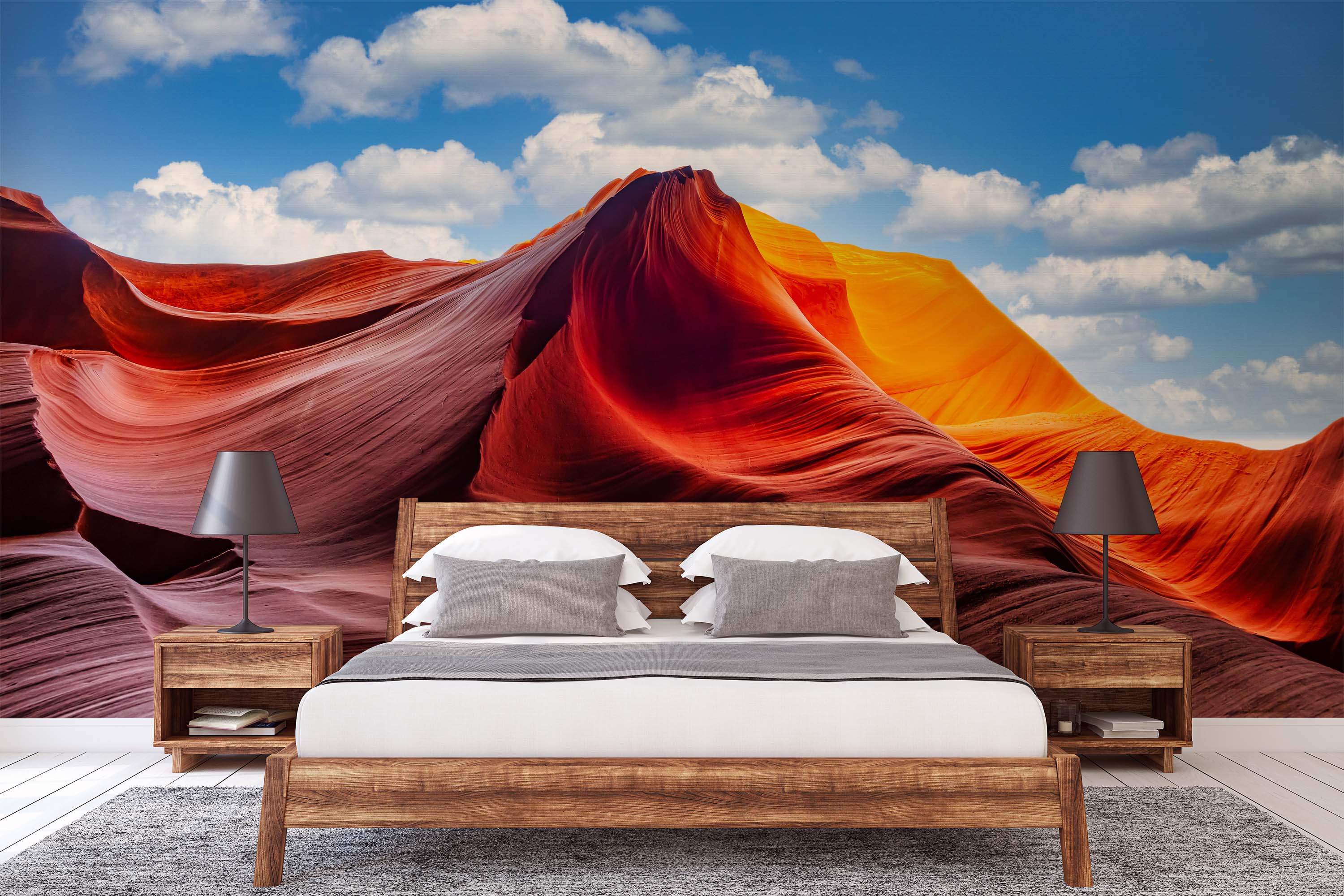 A landscape mural of a sunlit canyon with flowing red, orange, and yellow rock formations under a bright blue sky with clouds.