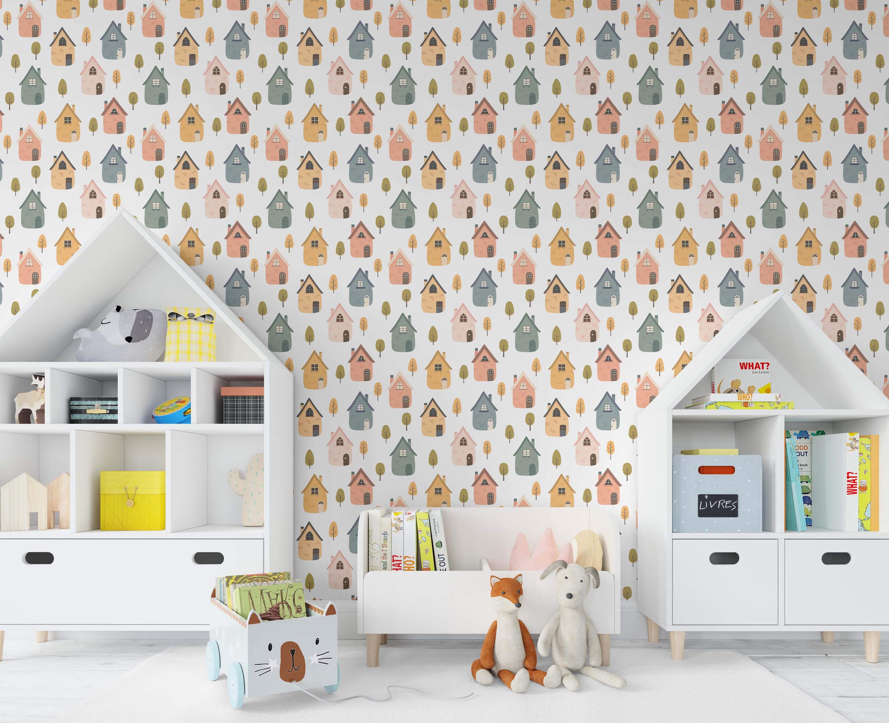 Cute repeating wallpaper pattern of stylized houses in yellow, peach, blue, and green, with small trees on a white field.