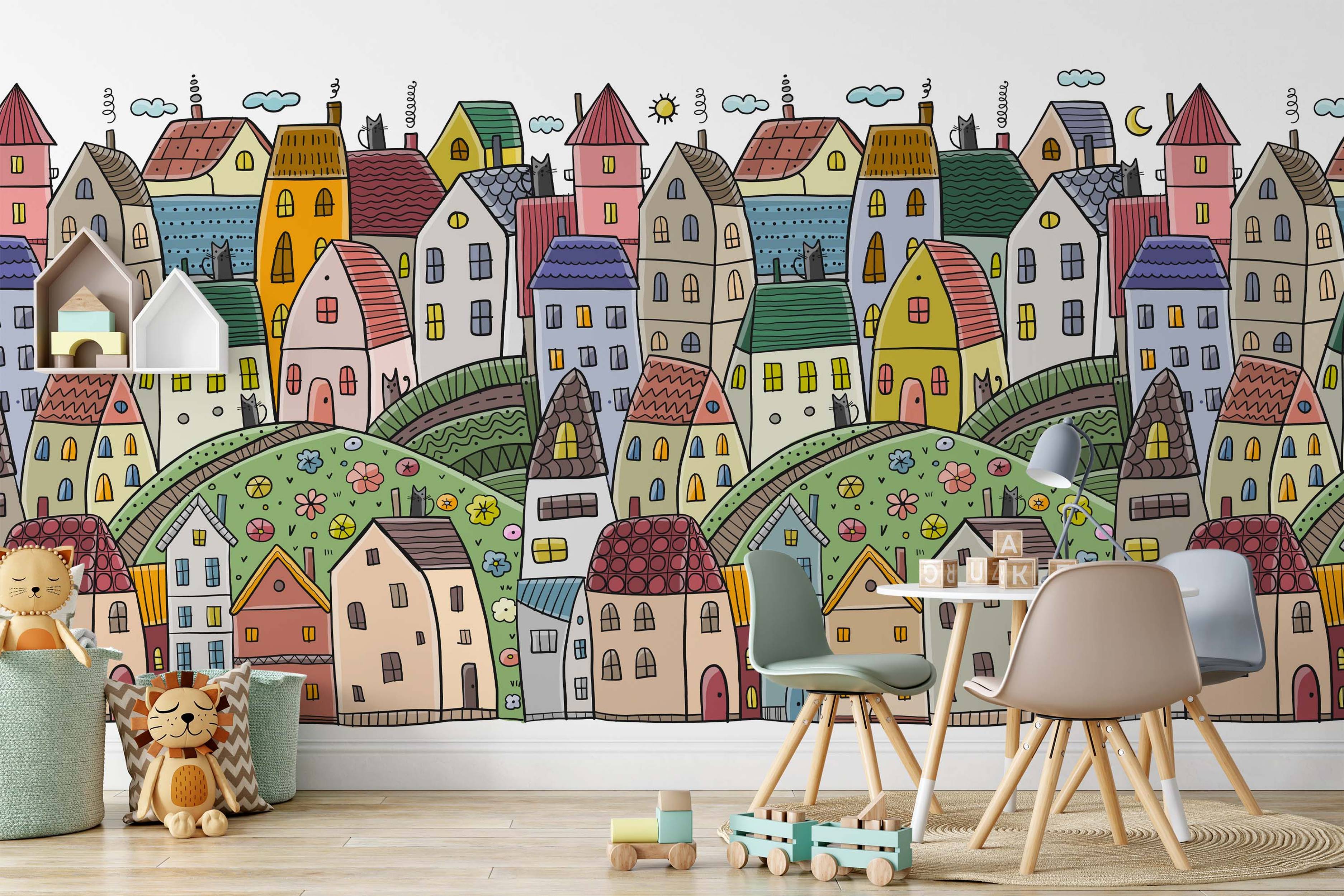 Whimsical cartoon village mural depicting colorful houses on rolling green hills, with black cats, clouds, sun, and moon details.