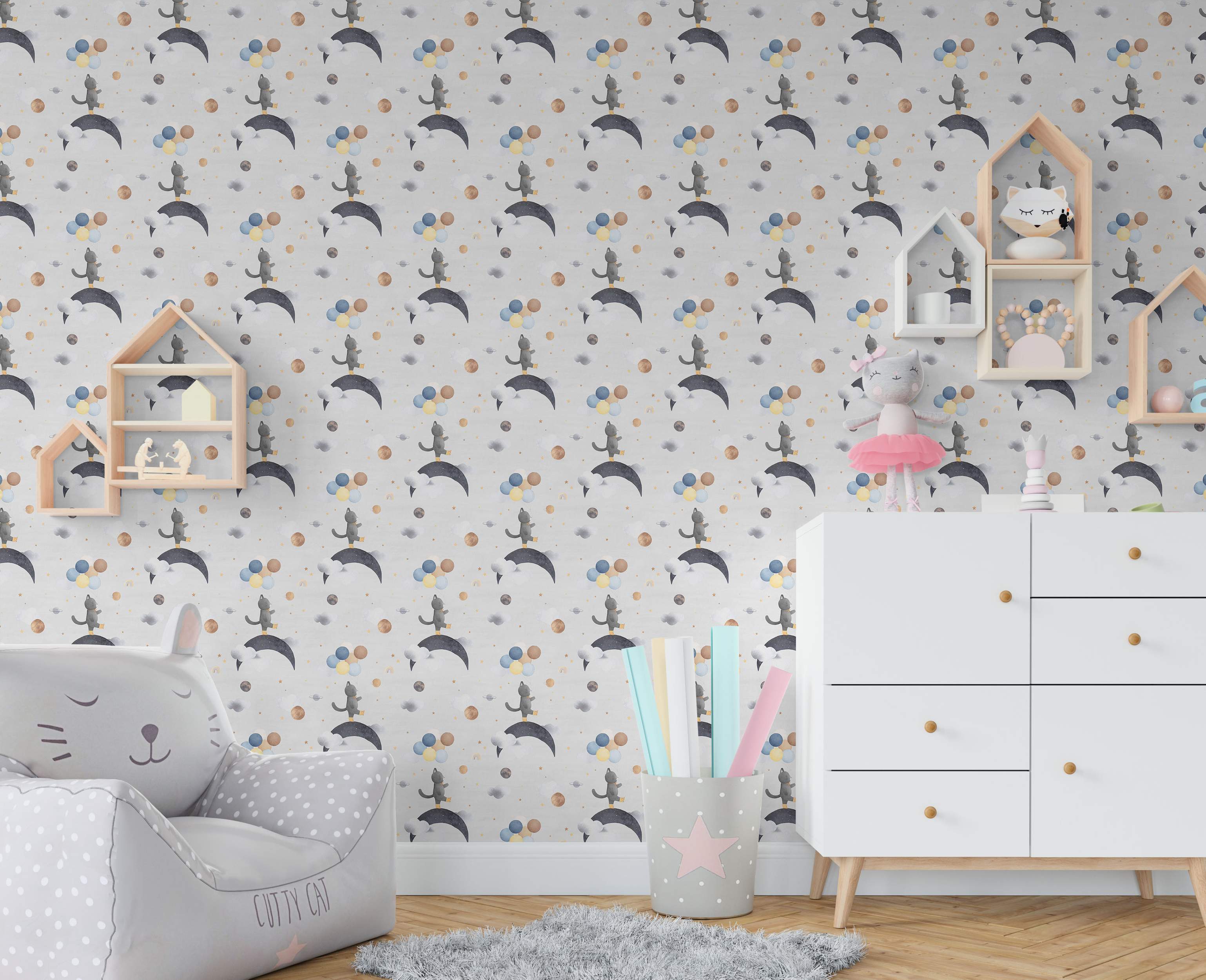 Repeating wallpaper pattern of cute gray cats on moons with colorful balloons, planets, and stars on a light background.