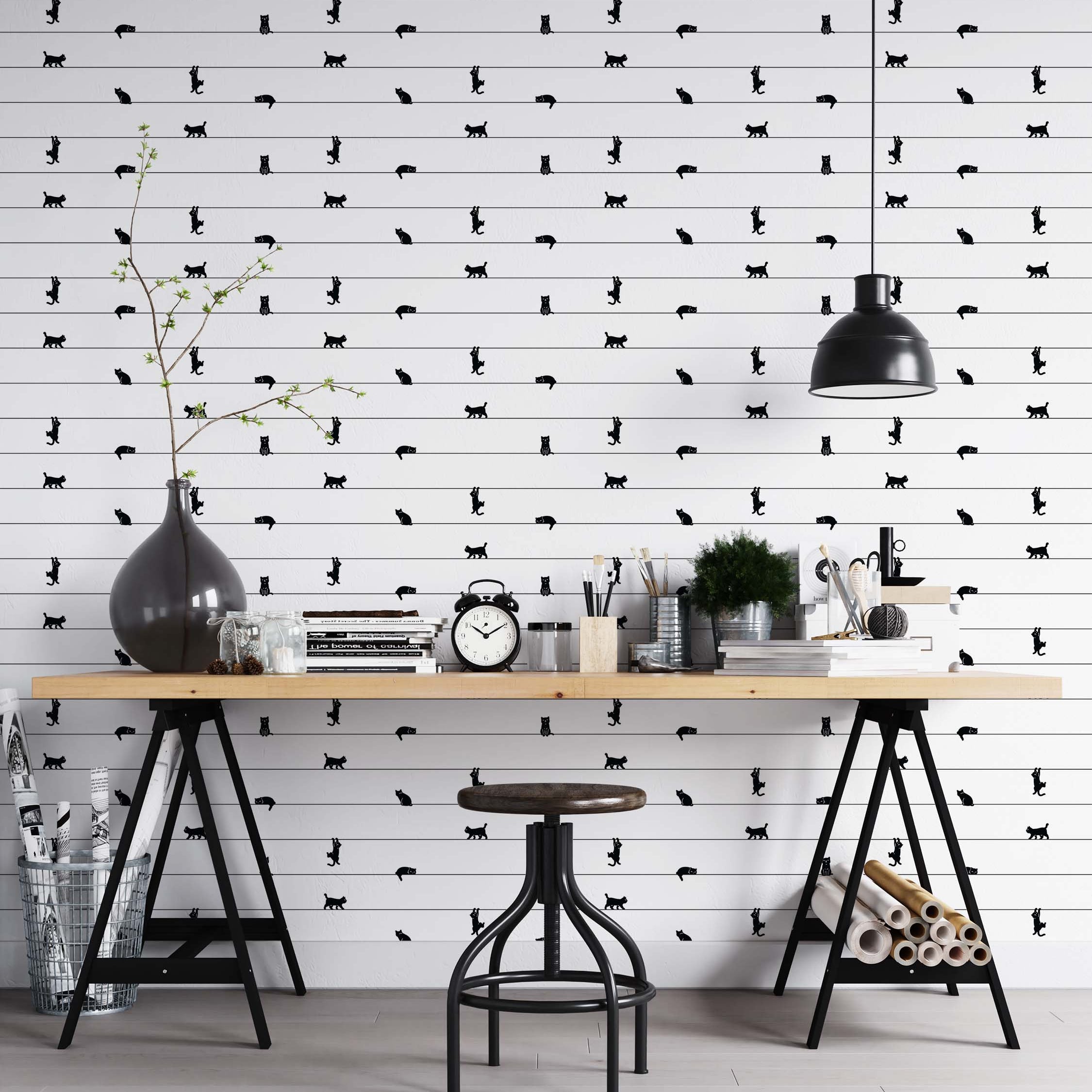Wallpaper with black cat silhouettes in various poses on thin horizontal lines over a white, horizontally paneled wall.