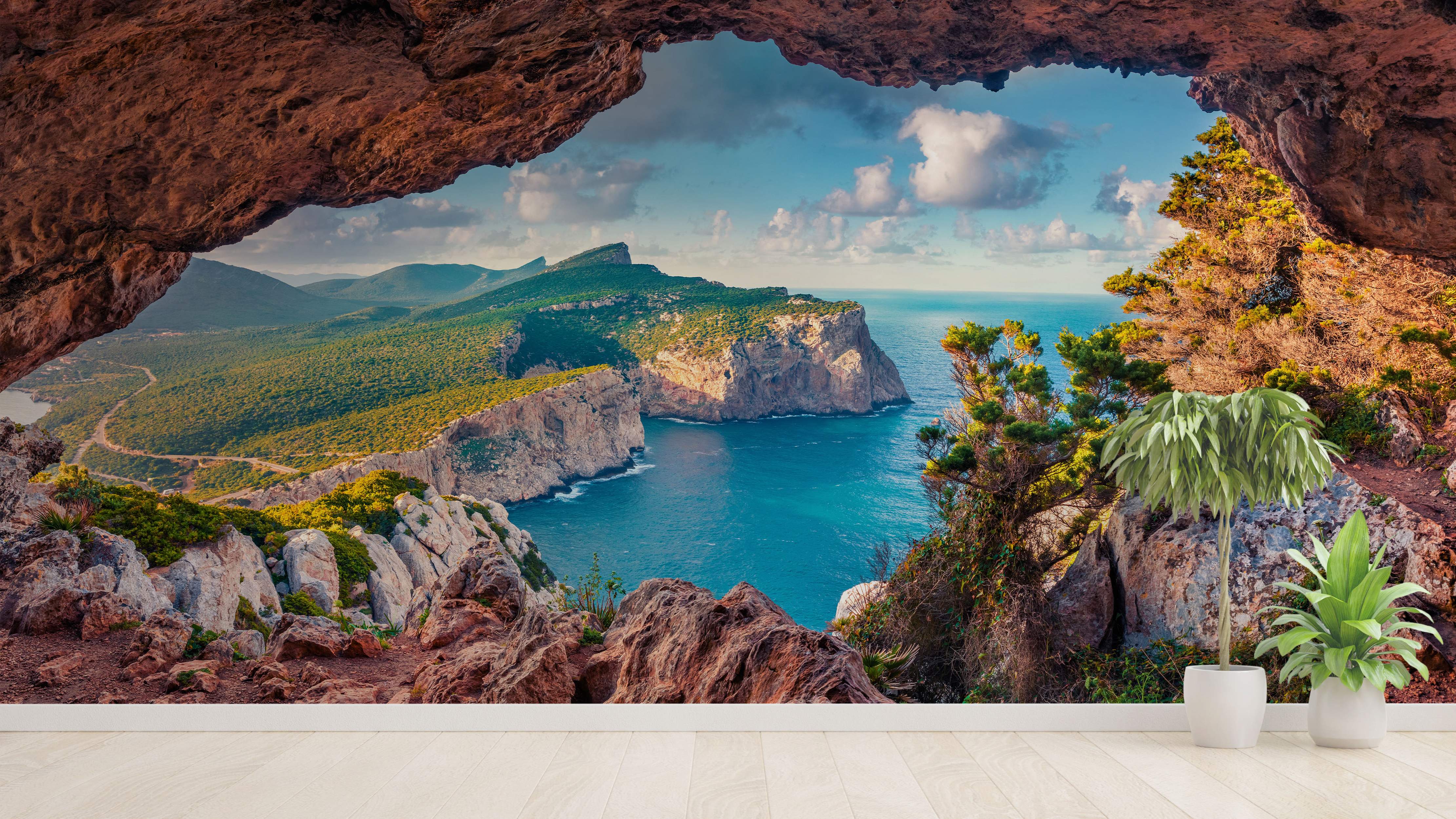 Scenic landscape mural viewed from a cave, showing green cliffs dropping into blue ocean water under a partly cloudy sky.