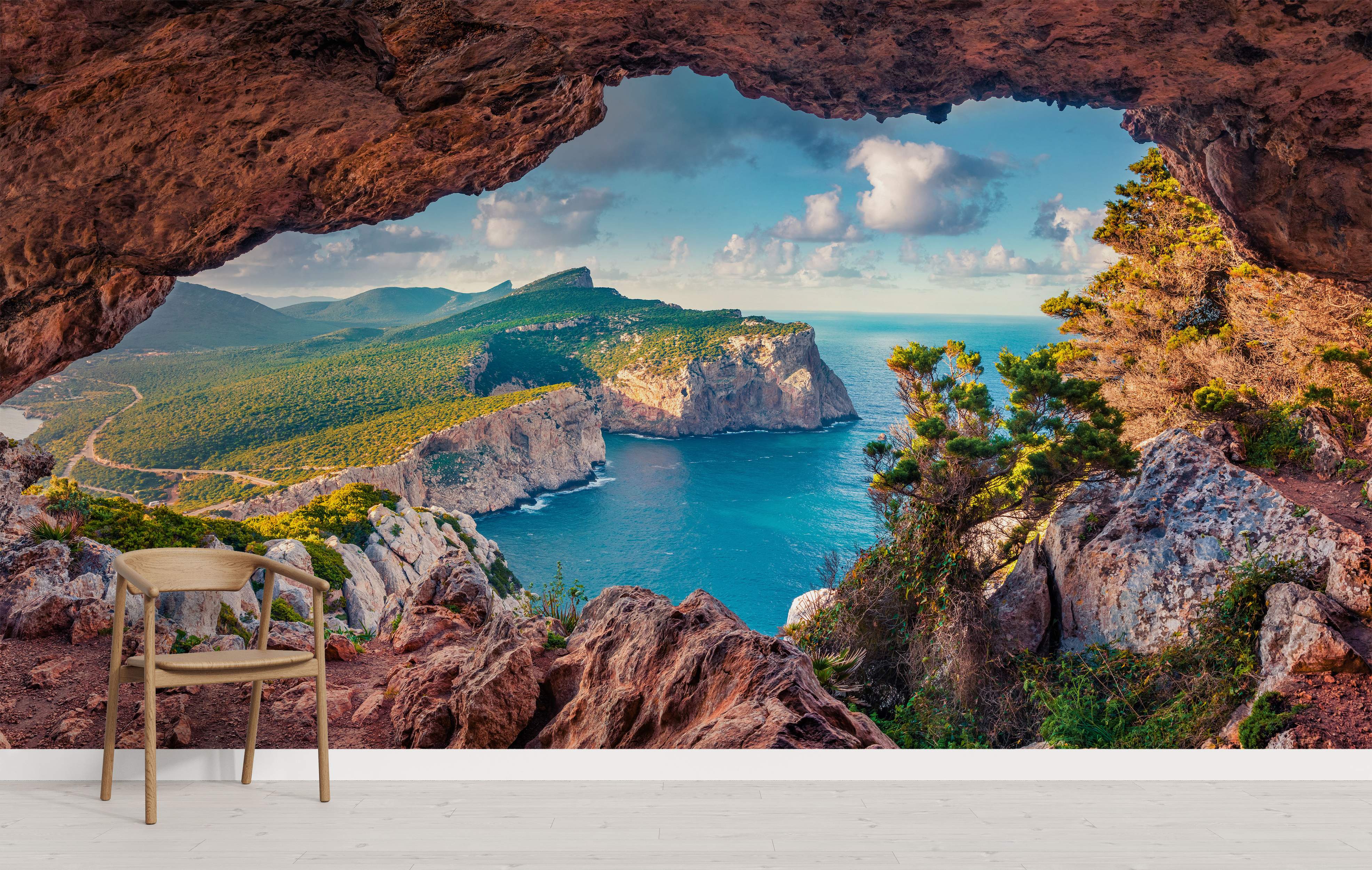 Mural showing a view from a brown rock cave overlooking green coastal cliffs, a bright blue sea, and a partly cloudy sky.