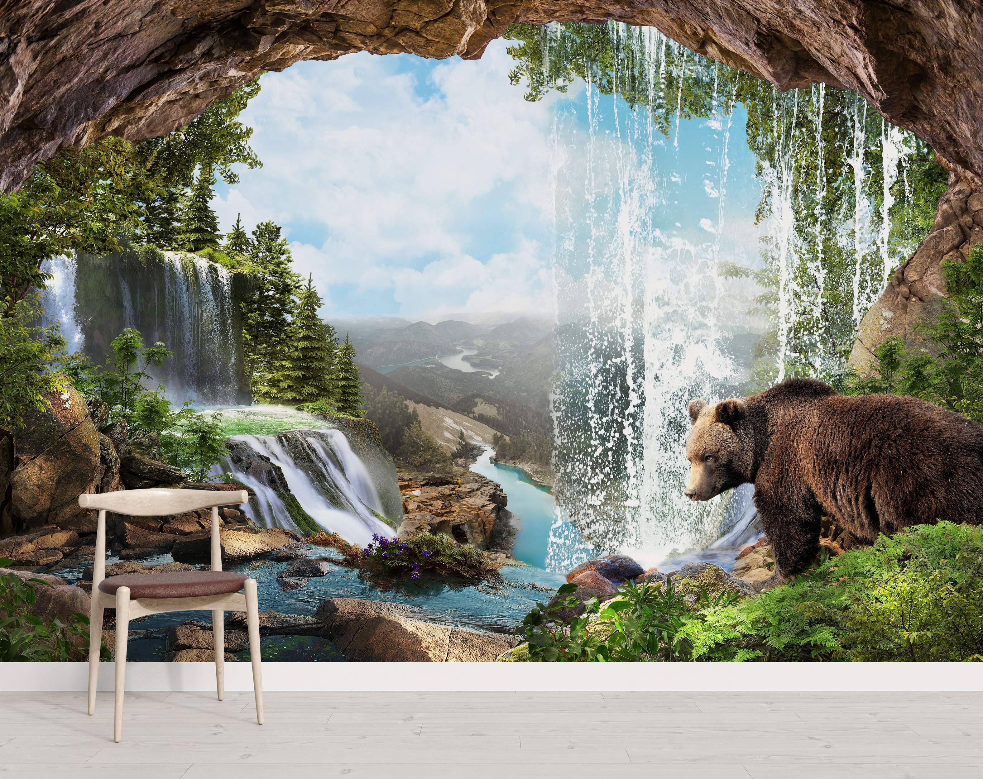 Mural depicting a view from a cave overlooking waterfalls, green trees, distant mountains, a river, and a brown bear.