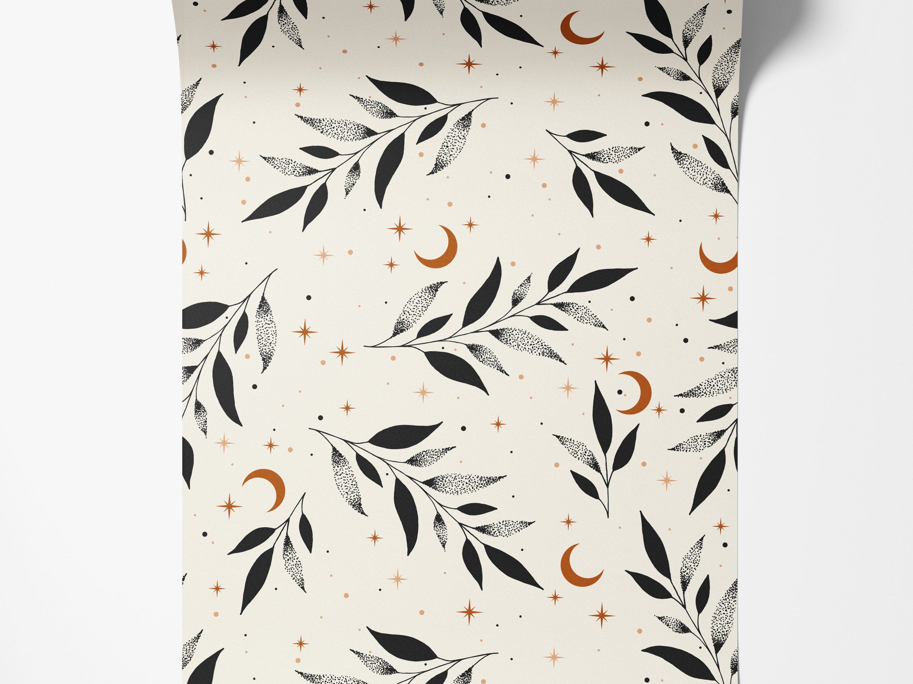 A celestial wallpaper with black stippled leaves, rust-colored crescent moons, and stars on a cream background.