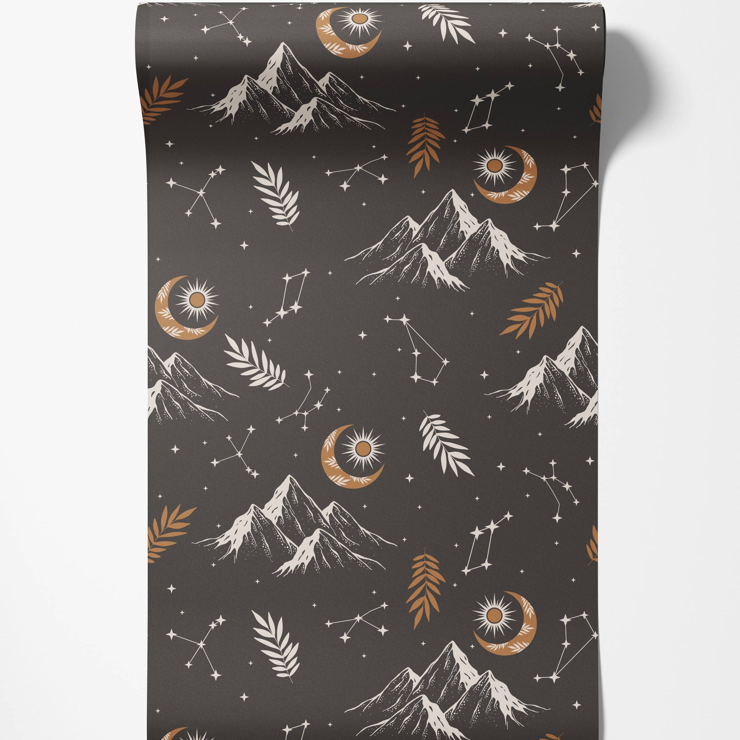 Celestial wallpaper with white mountains, gold crescent moons with suns, constellations, and leaves on a dark gray background.