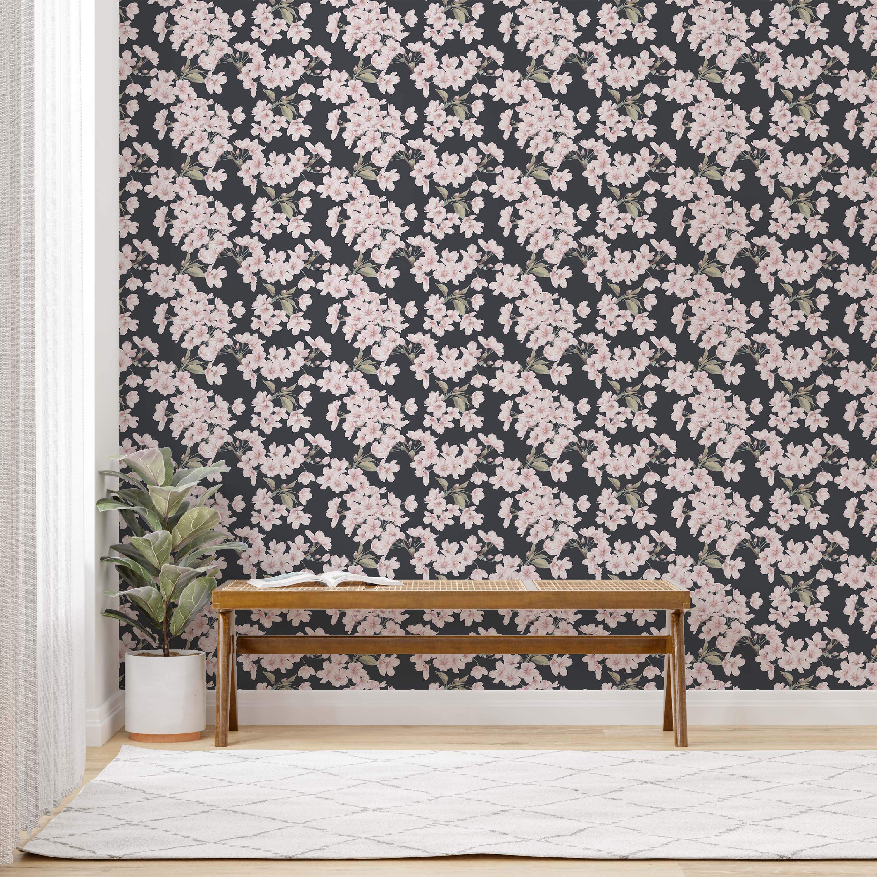 Wallpaper featuring repeating light pink cherry blossoms with green leaves scattered across a dark charcoal background.