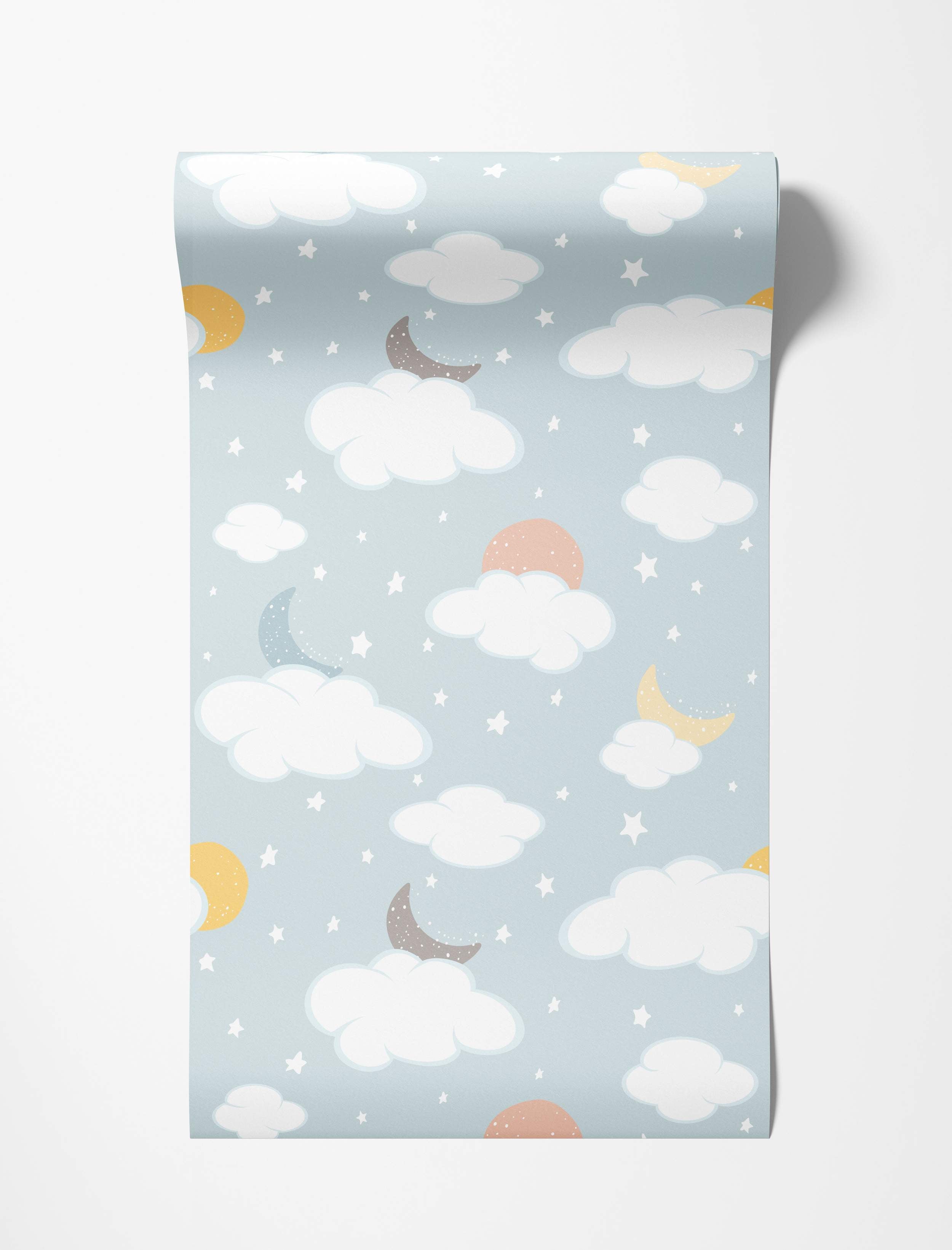 Children's wallpaper featuring white clouds, yellow, blue, and gray crescent moons, peach suns, and stars on a light blue sky.