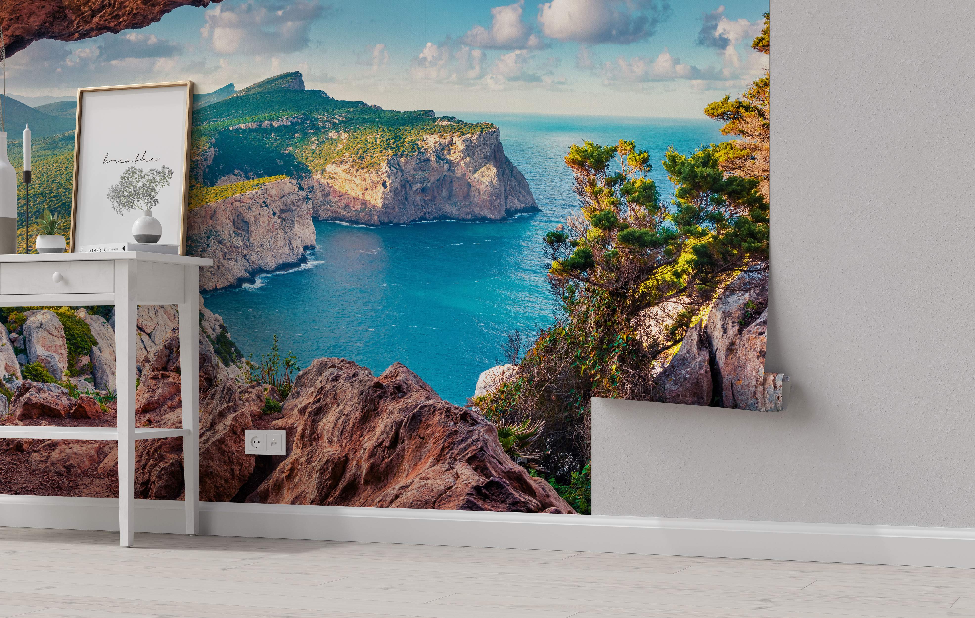 Scenic coastal mural depicting steep green cliffs meeting vibrant blue ocean water under a partly cloudy sky.