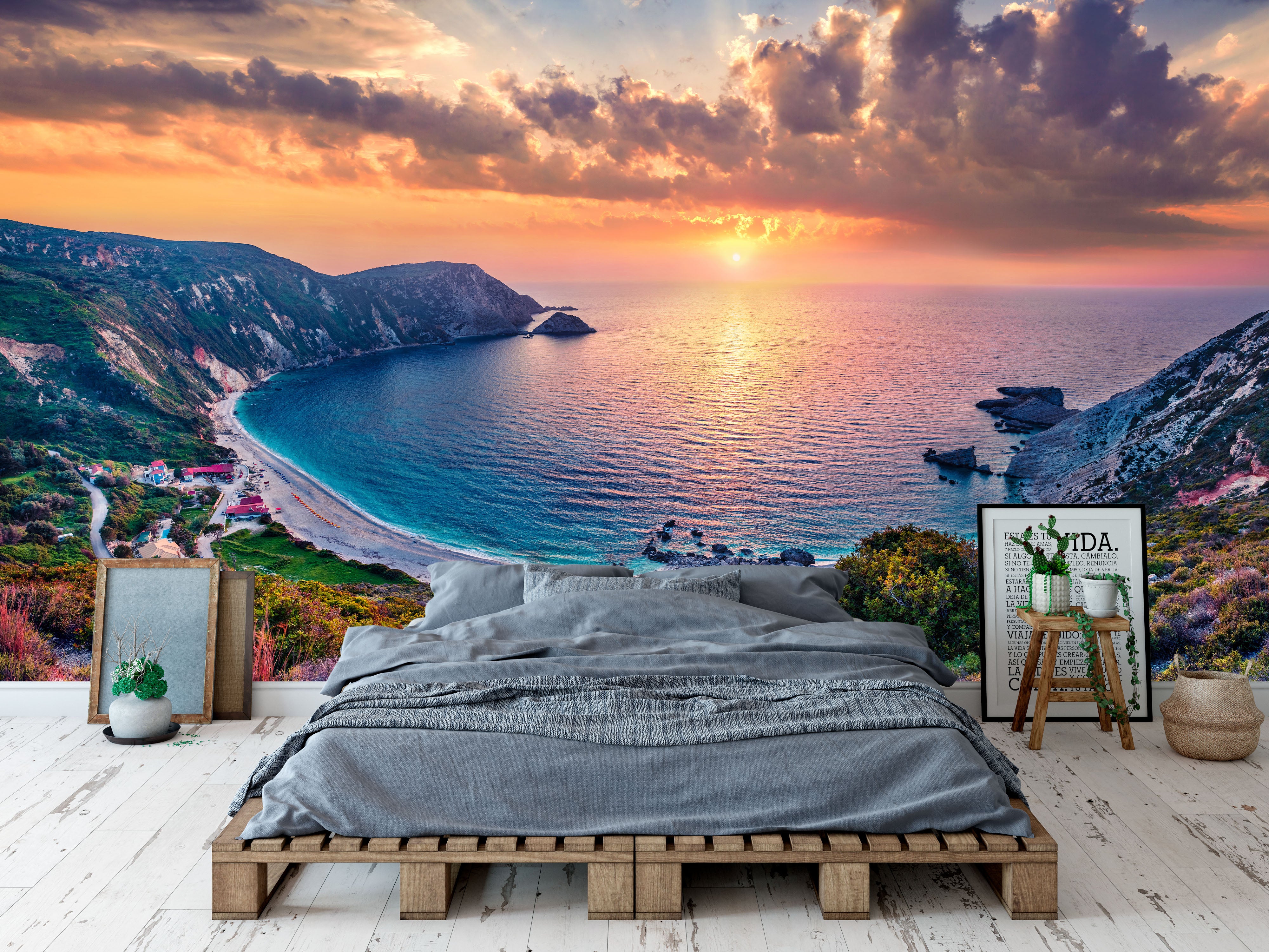 Mural featuring a dramatic sunset over a blue ocean bay, with cliffs, a sandy beach, and colorful clouds.