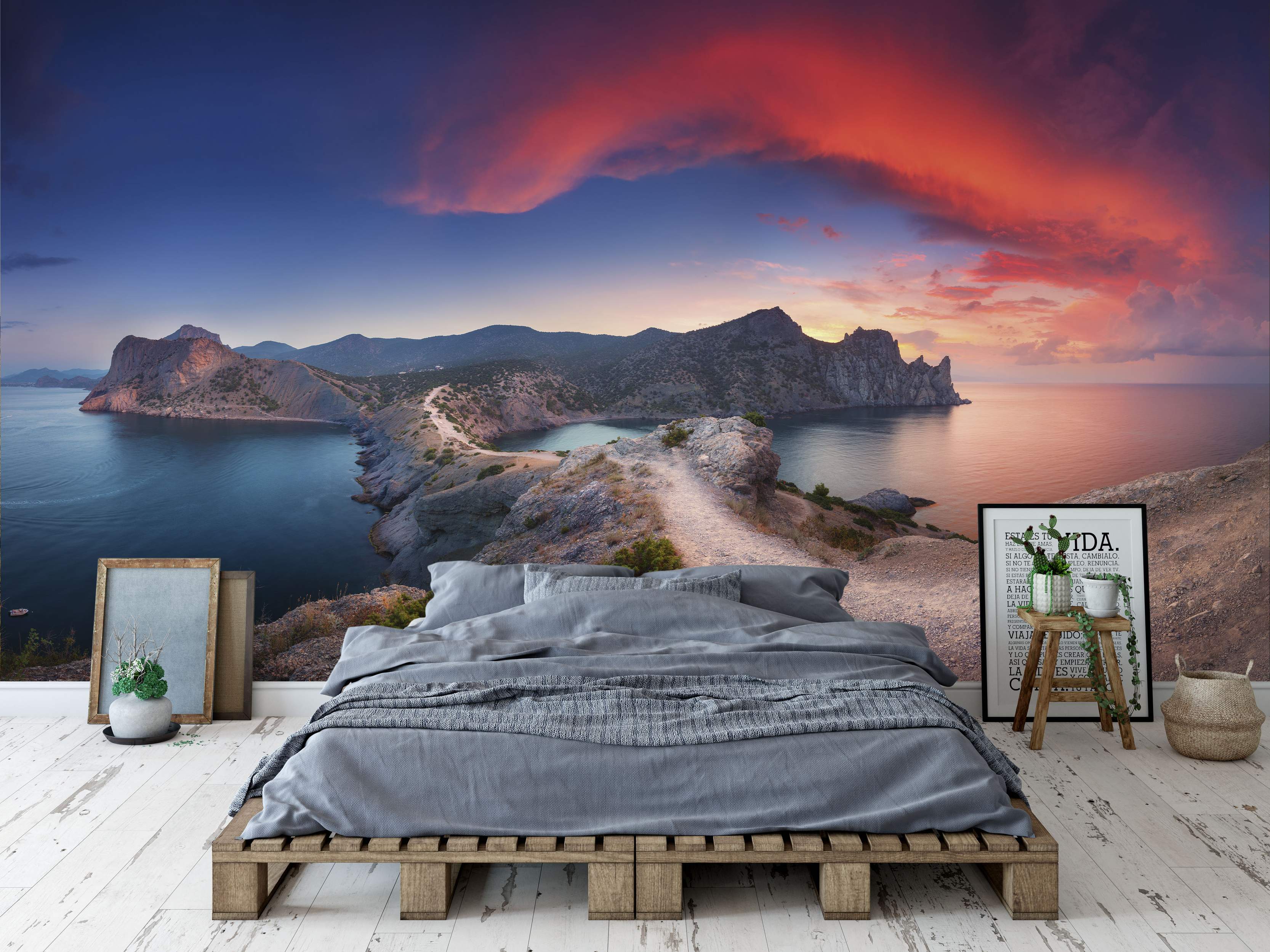 Mural featuring a stunning coastal landscape with cliffs, blue sea, and a vibrant red and orange sunset sky.