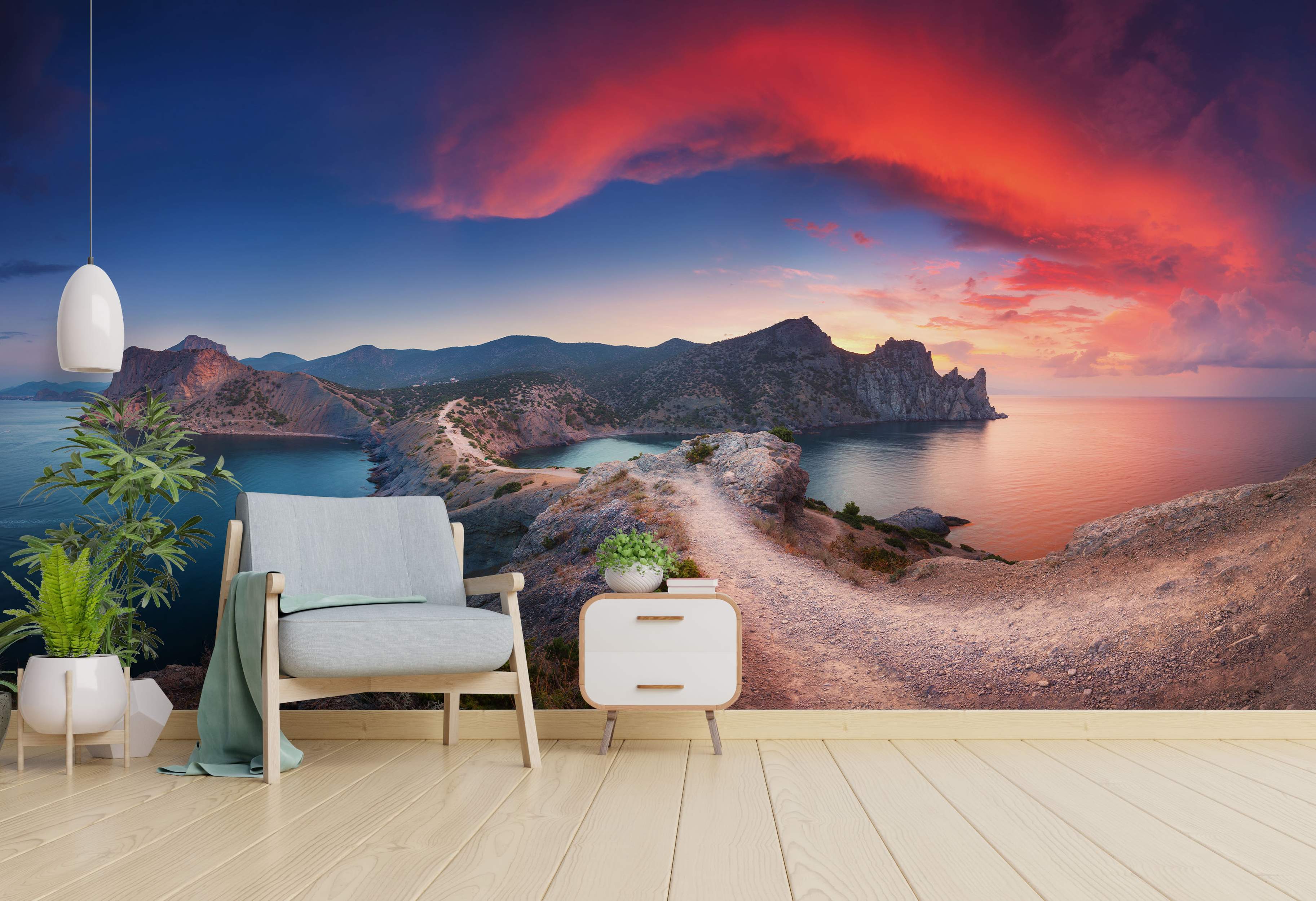 Coastal landscape mural depicting rocky cliffs by the sea under a dramatic red, orange, and blue sunset sky.