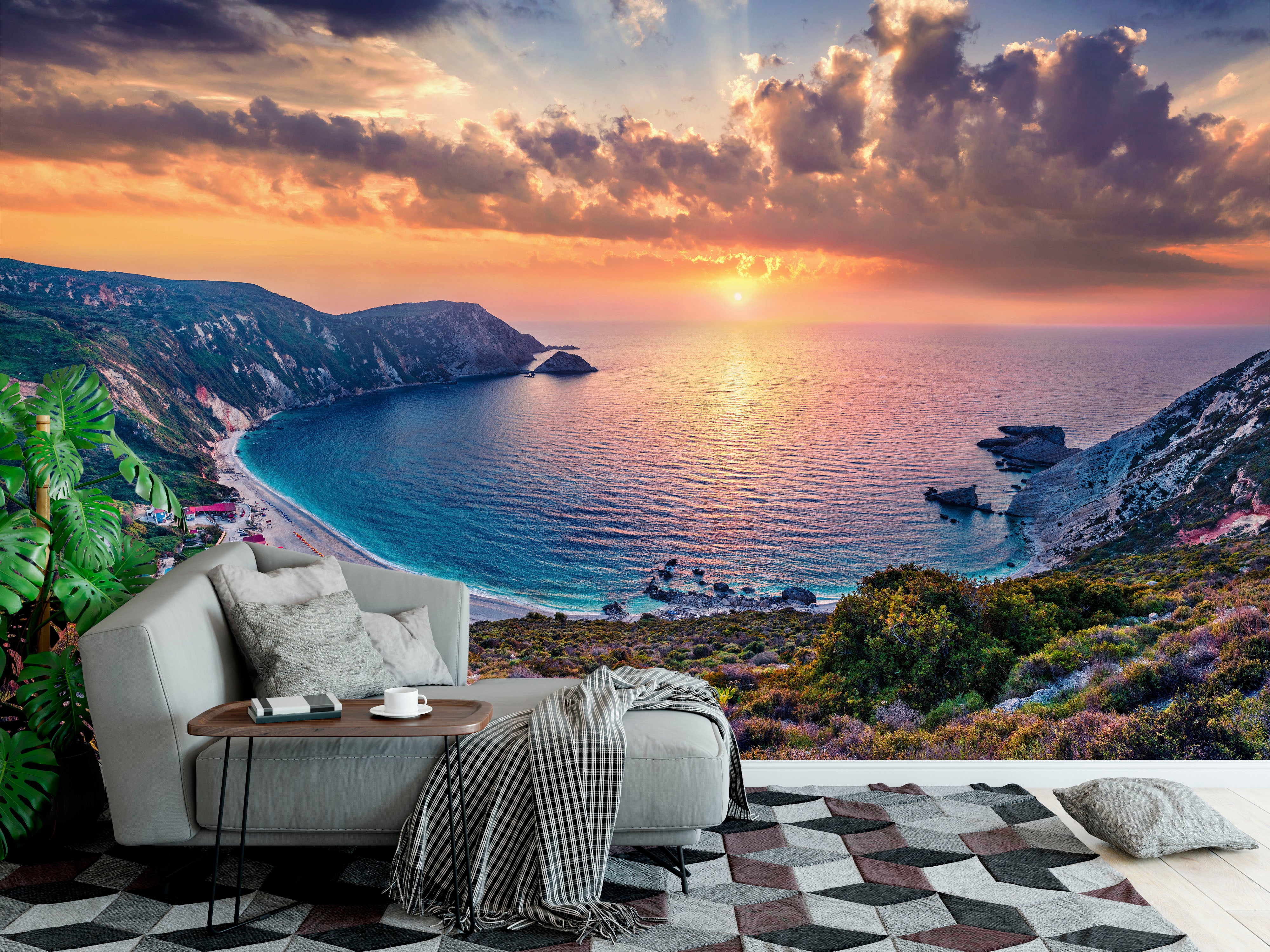 Mural depicting a vibrant coastal sunset over a bay with cliffs, turquoise water, and dramatic orange and purple clouds.