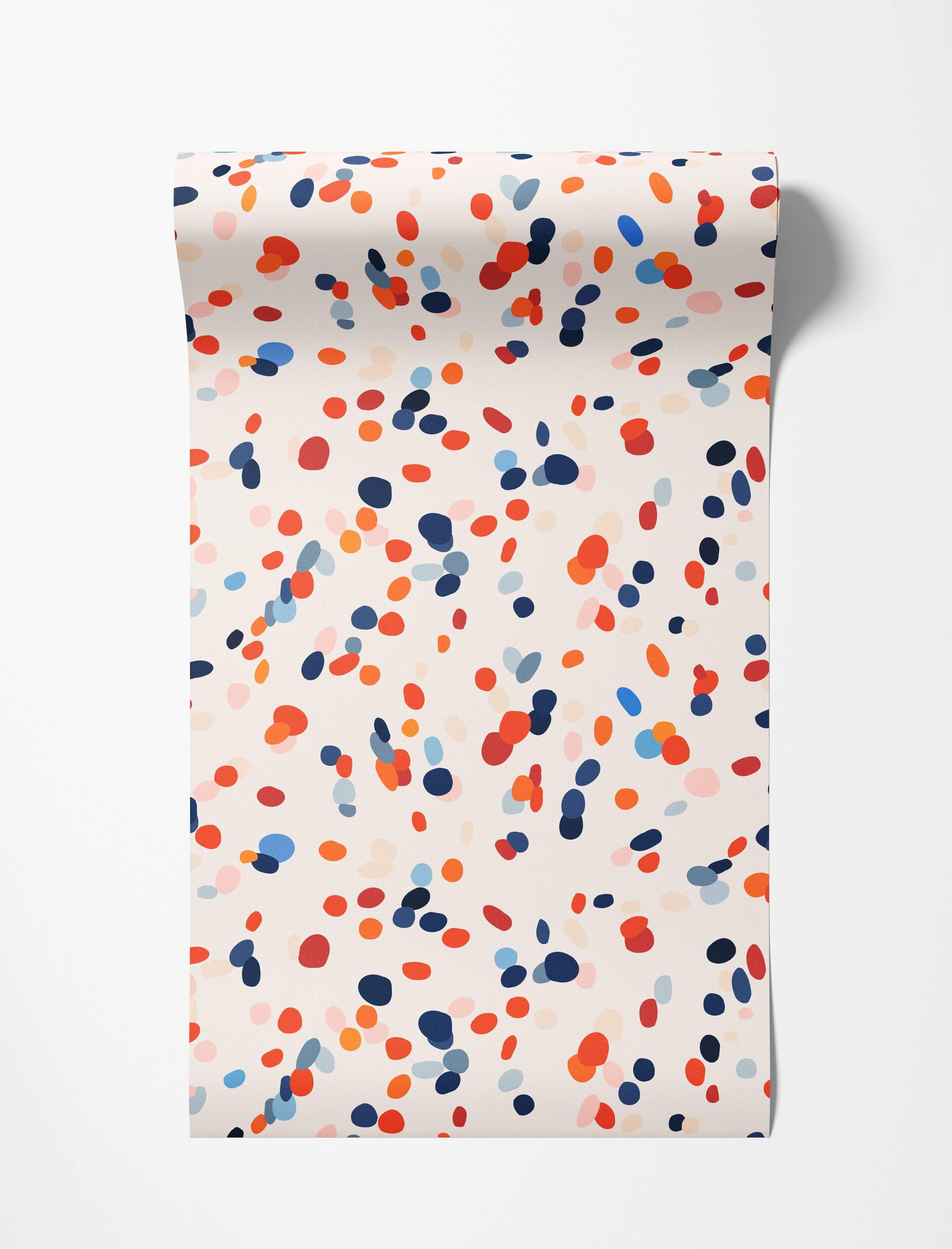 Abstract wallpaper featuring scattered oval confetti shapes in navy, red, orange, and light blue against a cream backdrop.