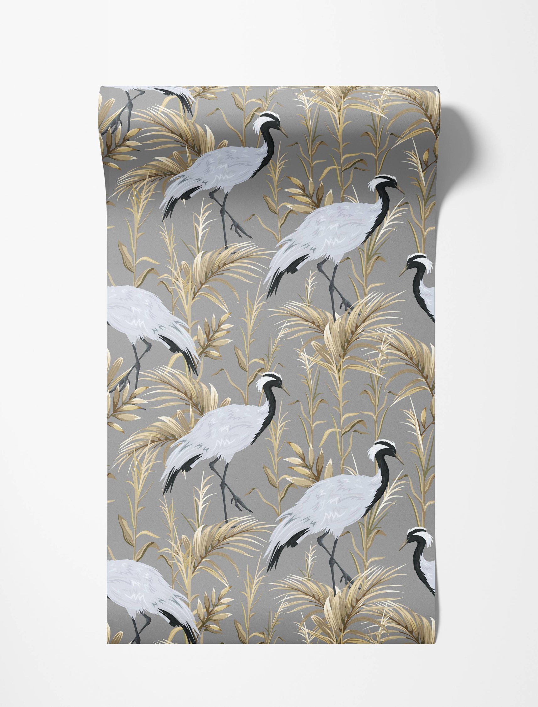 Elegant wallpaper with a repeating pattern of grey cranes with black and white heads among golden foliage on a grey background.